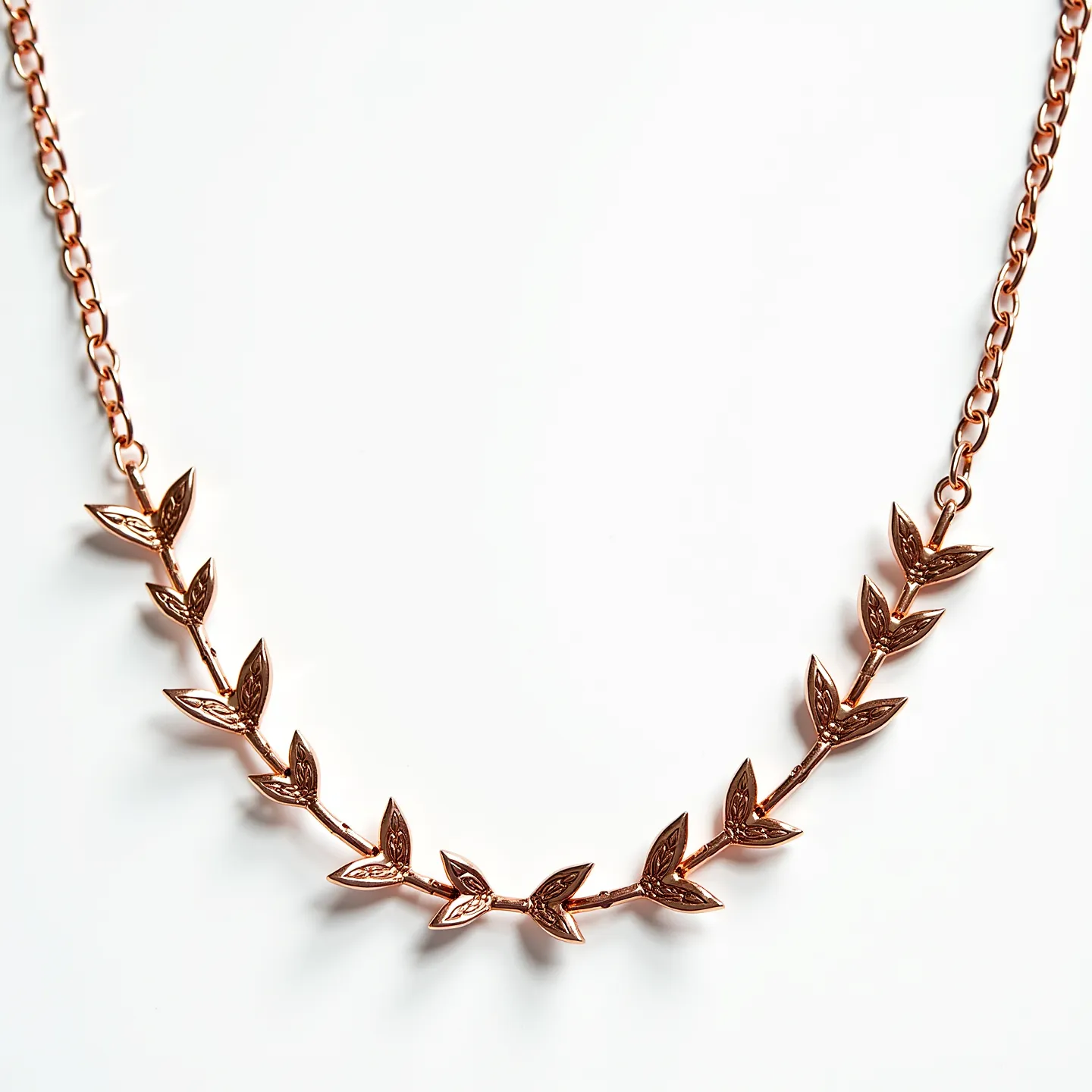 This long gold necklace features a delicate, artistic design resembling a vine with intricately crafted leaf motifs linked together along a slender chain. The leaves exhibit a refined rose gold hue, emphasizing a warm and elegant appearance. The leaves are uniformly arranged, showcasing meticulous detailing that contributes to the necklace’s overall aesthetic appeal. Each leaf is securely integrated into the chain, ensuring a seamless flow throughout the piece. The necklace is complemented by a sturdy lobster clasp, offering both functionality and security to the wearer. Its craftsmanship and design highlight an exquisite blend of simplicity and sophistication.