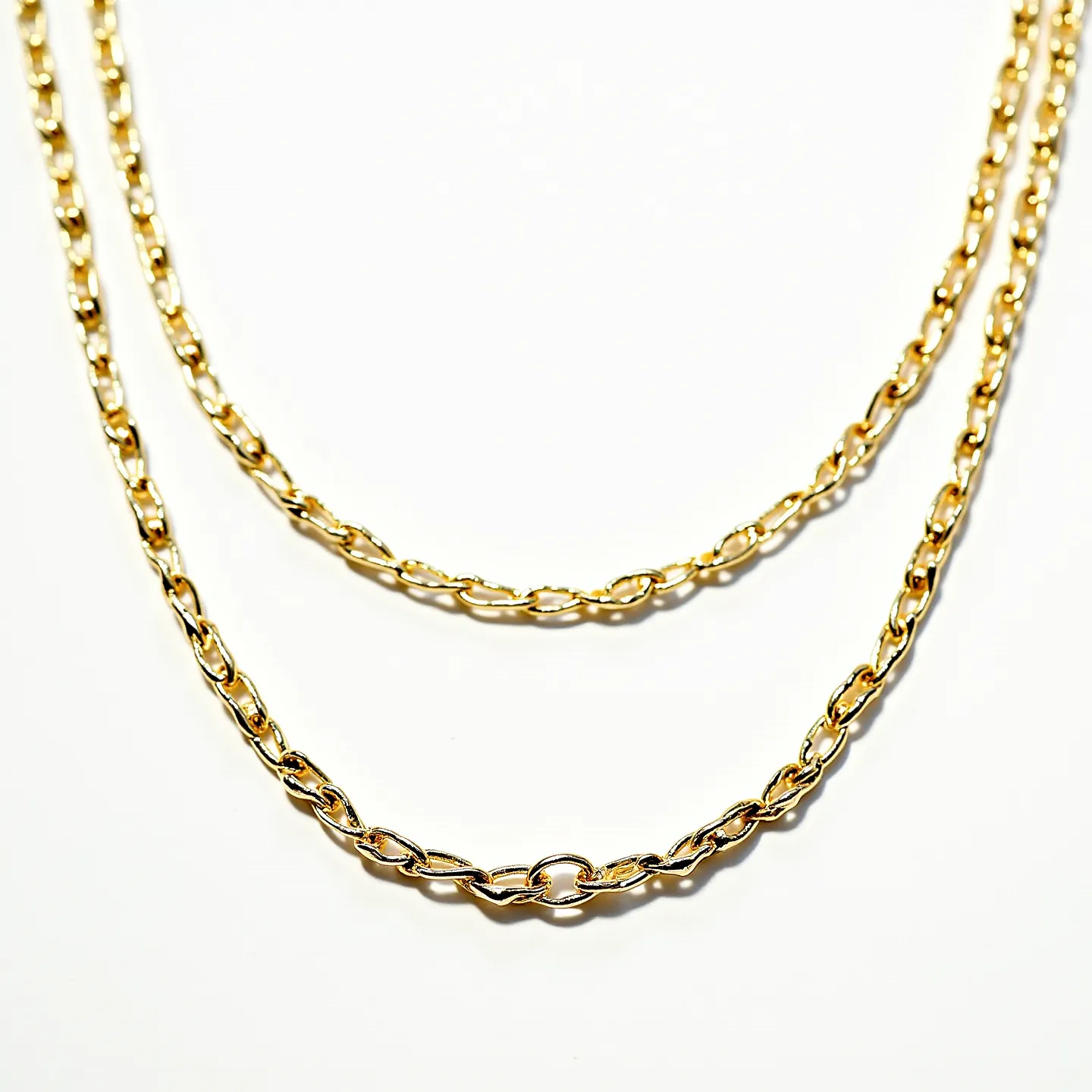 This long gold necklace features a classic chain design, composed of interlocking links that give it a smooth, elegant appearance. The links are polished, reflecting light to enhance the rich gold tone. It is crafted entirely from gold, showcasing a consistent sheen across its length. The design does not incorporate any gemstones, focusing instead on the allure of the metal itself. The necklace’s construction suggests durability and an understated sense of luxury, suitable for both casual and formal wear.