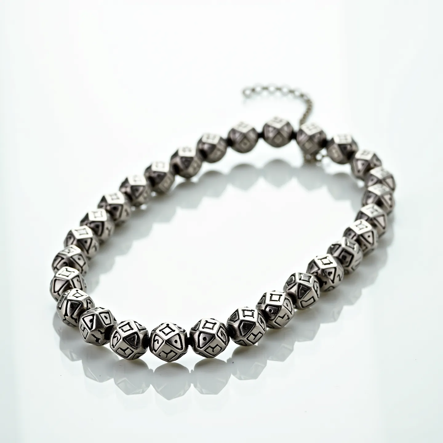 This men's beaded necklace features intricately designed metal beads, each adorned with geometric patterns that provide a bold, modern look. The beads appear to be made of a silver-toned material, likely stainless steel or another durable metal, and are uniformly shaped, possibly resembling small octahedrons, which give the necklace a consistent aesthetic. The necklace is finished with a delicate chain extender, suggesting it features an adjustable clasp for a customizable fit, enhancing versatility in wear. The overall design combines traditional beadwork with contemporary elements, making it suitable for various styles and occasions.