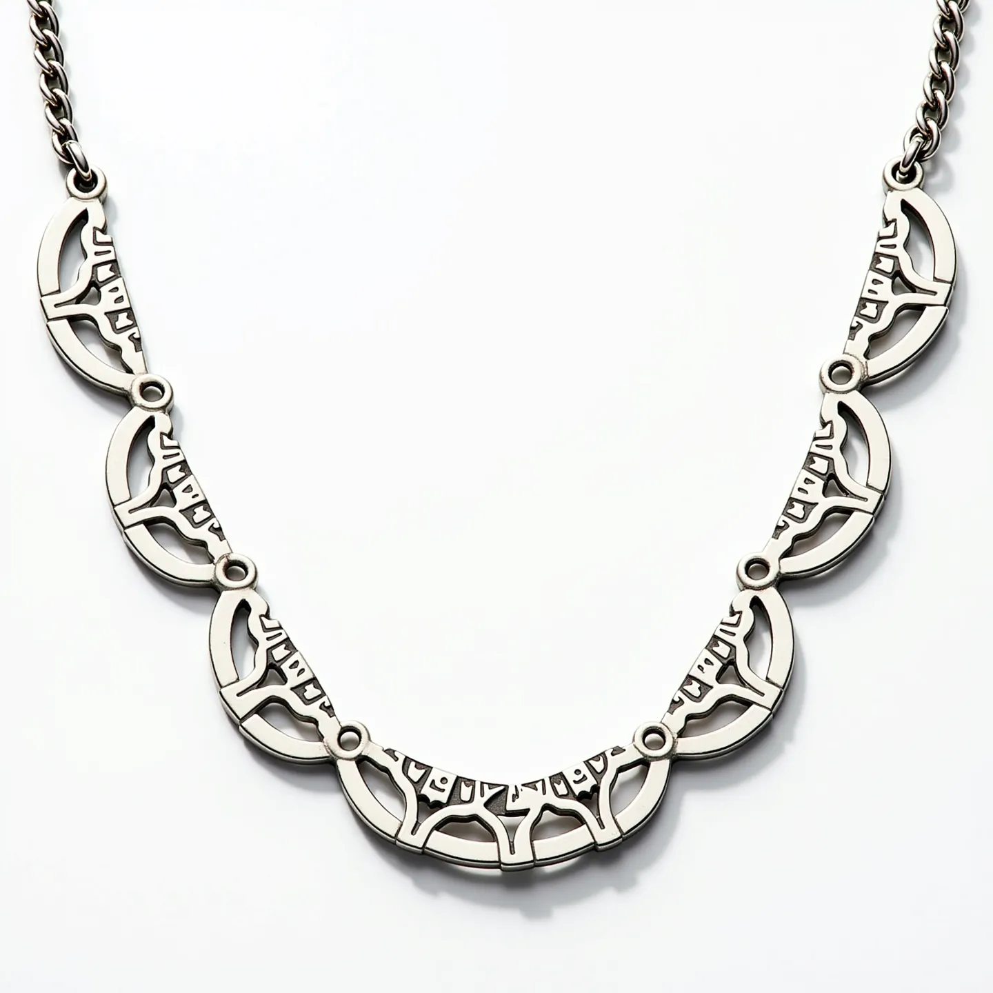 This men's necklace features a distinctive design with interconnected metal sections. The material appears to be a high-quality metal, likely stainless steel, known for its durability and modern aesthetic. The necklace is composed of several crescent-shaped segments that are intricately designed with geometric cut-outs, adding an artistic flair. The segments are connected by small circular links that offer flexibility and a cohesive look. There is no visible gem or stone in the design, maintaining a sleek and minimalist appearance. The necklace is finished with a robust metal chain that suggests a clasp or traditional attachment method for secure fastening.