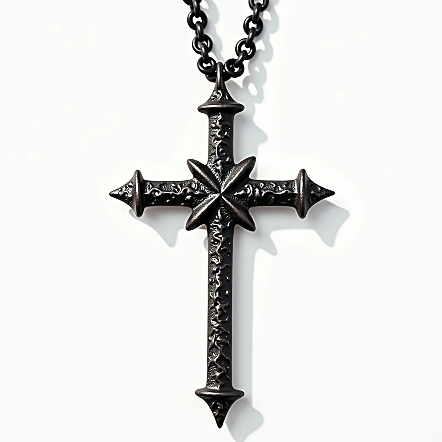 This nail cross necklace features a bold design formed from dark metal, crafted to mimic the look of ancient, rugged nails. The cross is intricately etched with decorative patterns, enhancing its striking appearance. At the intersection of the cross sits a star-like embellishment that adds depth to its design. The pendant is suspended from a sturdy chain, which comprises interlocking links, providing both durability and a cohesive style. The necklace is finished with a simple, functional clasp that allows for secure wear and easy removal.