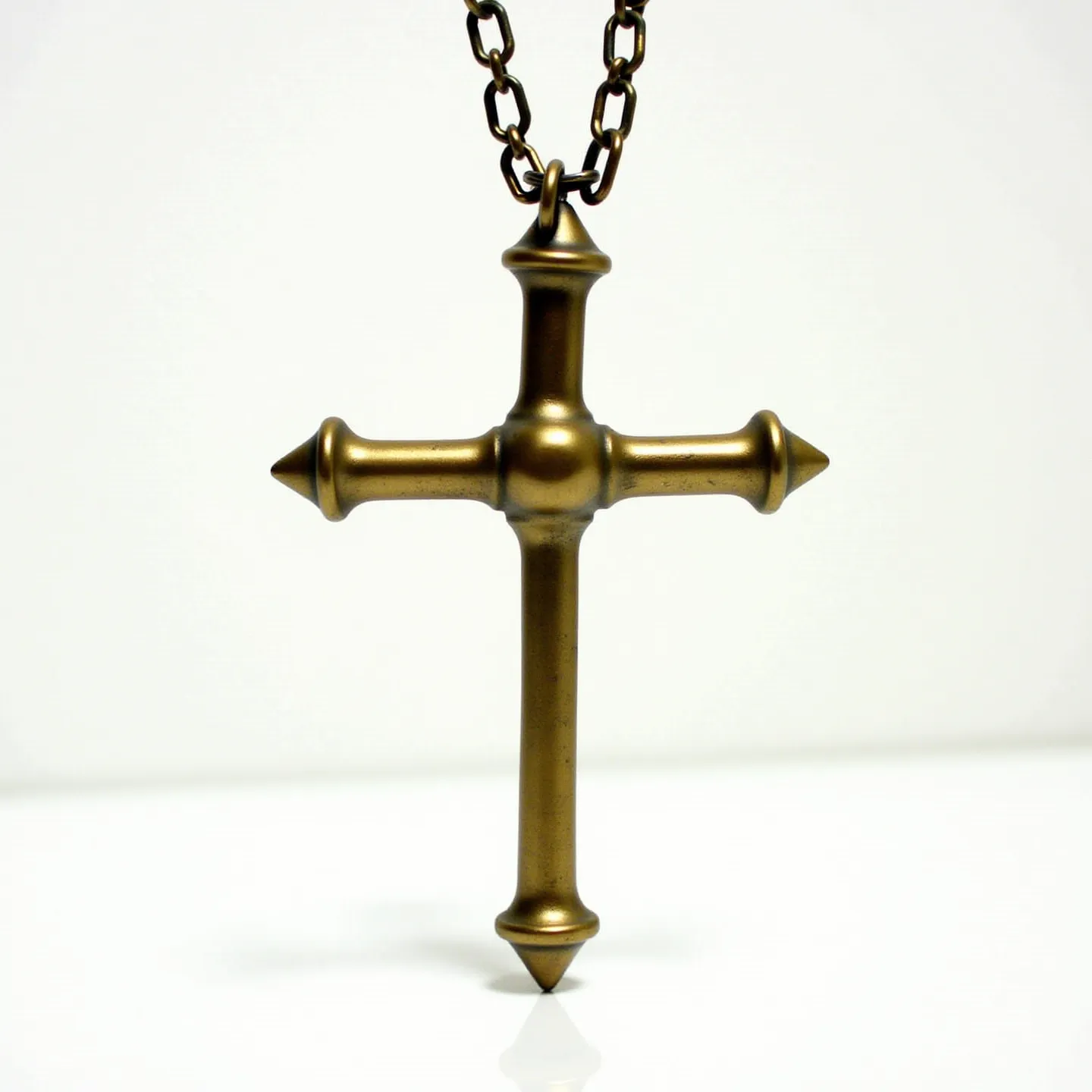 This nail cross necklace features a design that mimics the appearance of nails forming the shape of a cross. Made from a metal with a brass or bronze finish, the cross has a rustic and antique appearance, providing a vintage aesthetic. The pointed ends of the nails are designed symmetrically, adding a distinct and artistic touch to the piece. The cross is suspended from a chain with oval links, offering a sturdy and complementary look. The attachment is a typical loop that allows for easy handling and wear.