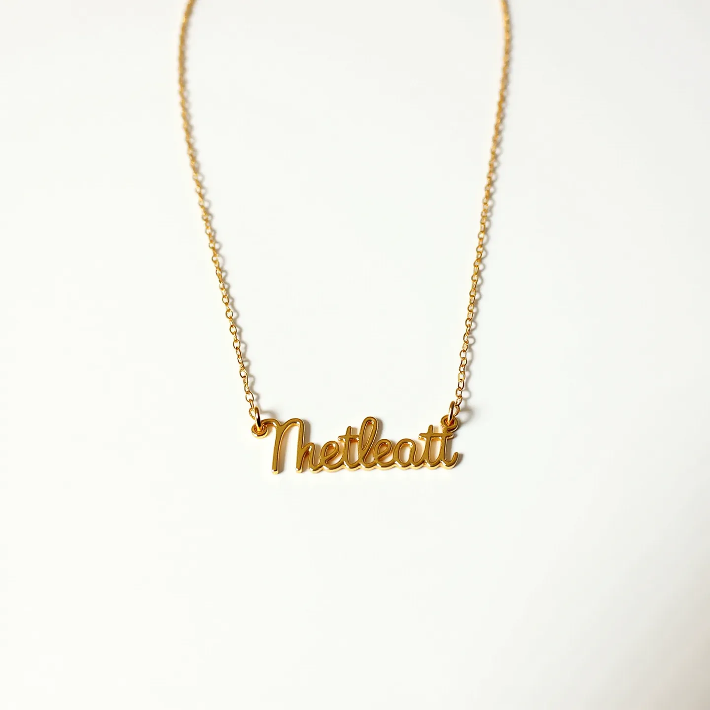 This name chain necklace features a delicate chain crafted from a gold-toned metal, adding a touch of elegance and sophistication. The pendant itself spells out a name in a graceful, cursive script, seamlessly integrated into the chain for a cohesive look. The chain appears to be of a cable style, offering both strength and flexibility, making it suitable for daily wear. It likely secures with a standard spring ring clasp, ensuring a reliable and easy closure. The overall design is simple yet chic, ideal for personalizing one's style.