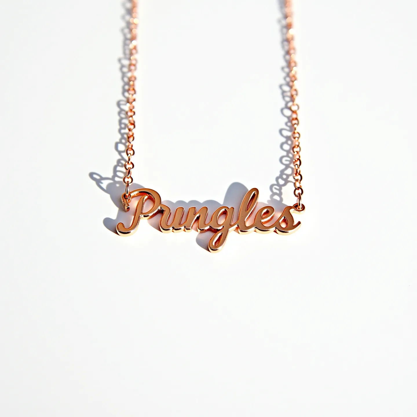 This name chain necklace features a script that spells out "Pungles," crafted from a gleaming rose gold-toned metal. The nameplate is seamlessly integrated into the delicate chain, which reflects a cohesive design. There are no visible gems or stones embedded in the necklace, maintaining a smooth and elegant appearance. The chain likely includes a standard clasp at the back to facilitate easy wearing and removal, though the specific type of clasp is not depicted. Its simplicity and shine create a stylish and personalized piece of jewelry.