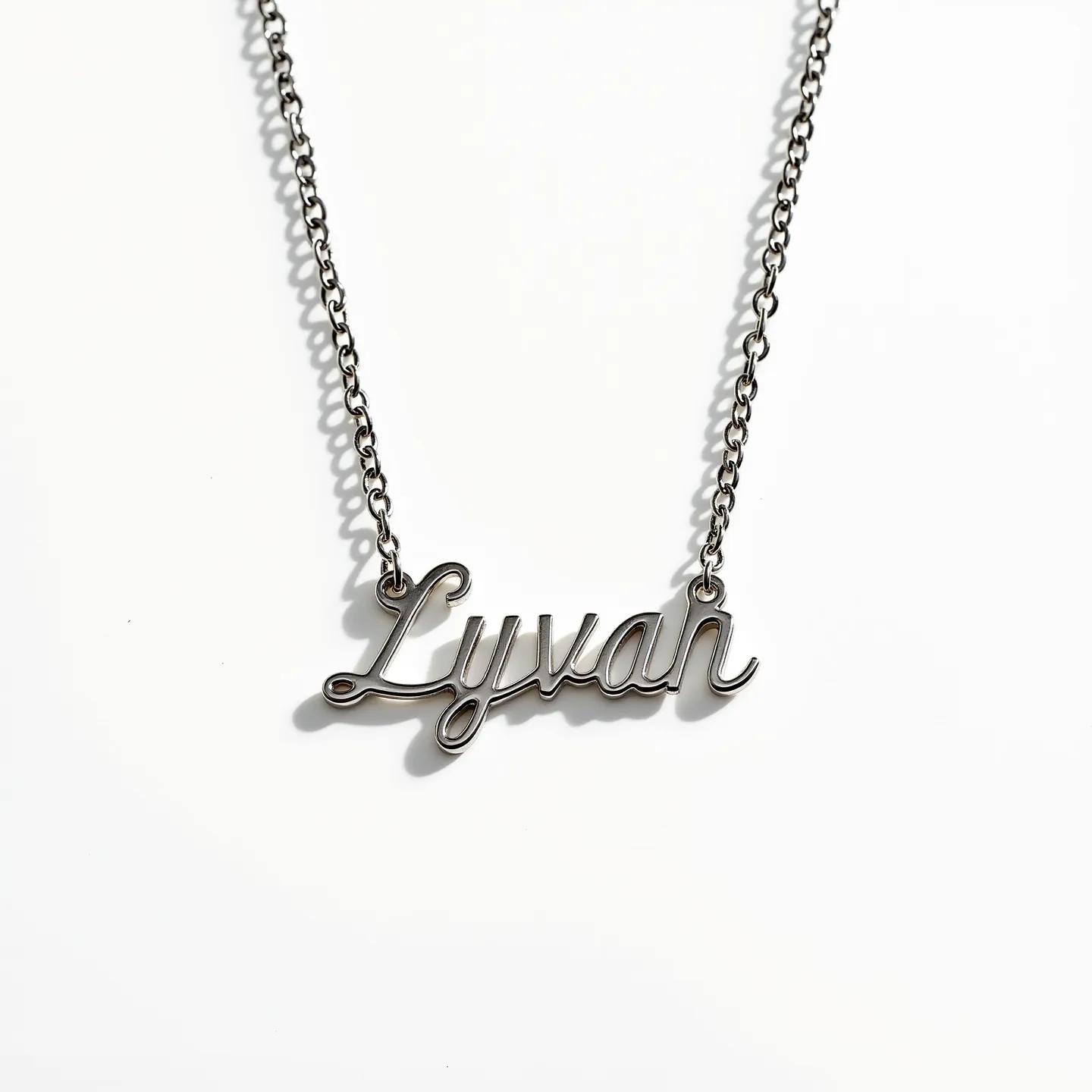 This name chain necklace features a polished metal material with a glossy finish, showcasing the name “Lyvan” in an elegant script font. The chain is composed of interlinked metal loops, creating a sleek and consistent aesthetic. The necklace does not incorporate any gemstones or additional adornments, allowing the focus to remain on the stylish presentation of the name. It includes a simple yet secure clasp for easy fastening, harmonizing with the overall minimalist design.