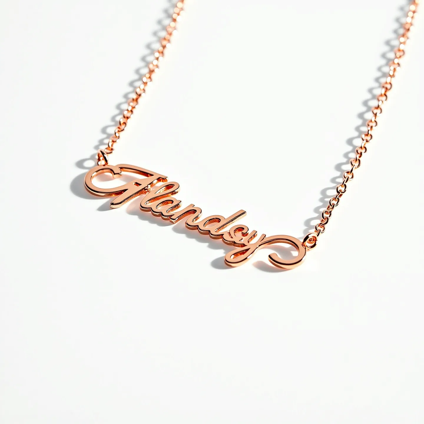 This name necklace features a sleek, cursive design that spells out the name in rose gold metal, giving it a warm and elegant appearance. The material appears to be rose gold-plated, adding a luxurious shine to the letters. The chain is composed of small, round links that complement the delicate style of the pendant. The name plate is seamlessly attached to the chain at both ends, ensuring that it hangs evenly. There are no gems or stones incorporated in the design, and the necklace likely closes with a classic lobster clasp, which is a common choice for ensuring secure wearability.