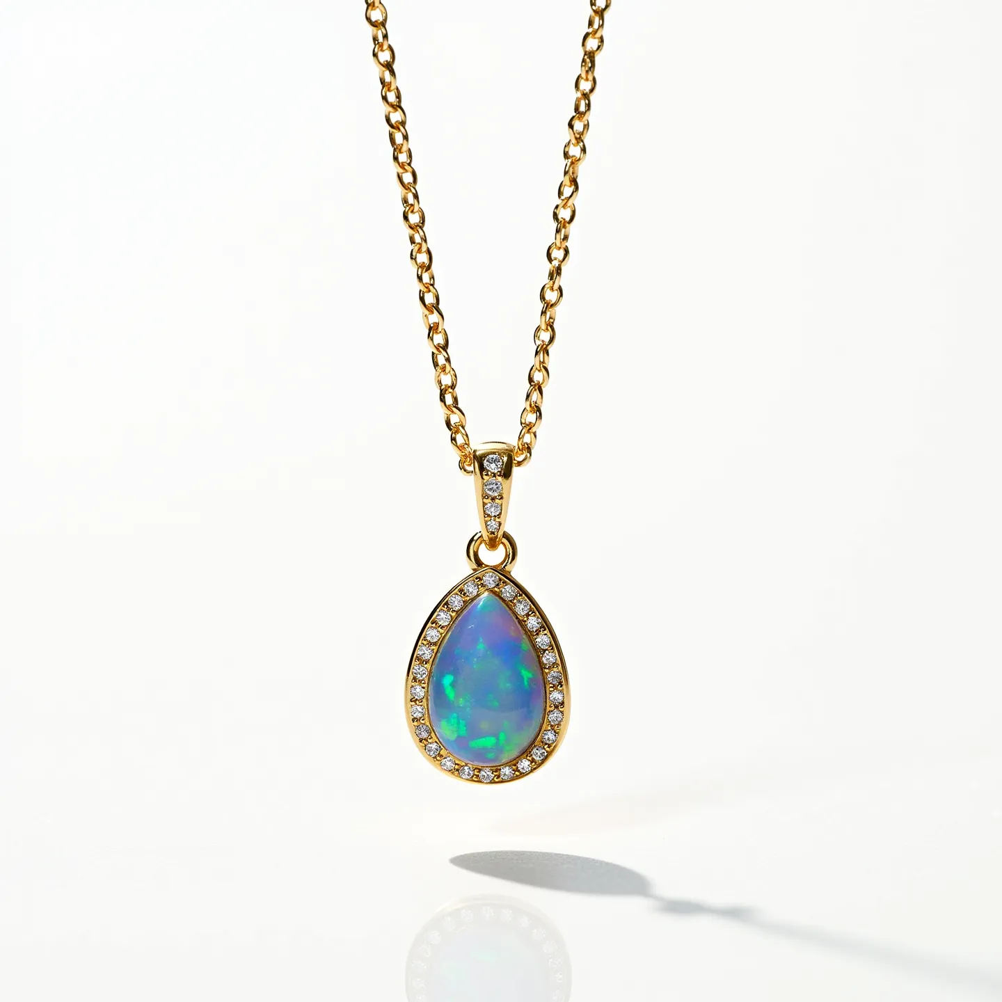 This opal necklace features a stunning pear-shaped opal set in a fine gold mounting. The opal displays vibrant hues of blue and green, characteristic of high-quality opals. Surrounding the central stone is a halo of small, clear gemstones, likely diamonds, which contribute a sparkling accent that enhances the opal’s play of color. The chain is crafted from a gold material, complementing the pendant and providing a unified, elegant appearance. A secure bail at the top of the pendant appears to be encrusted with additional clear stones, adding to the overall sophistication.