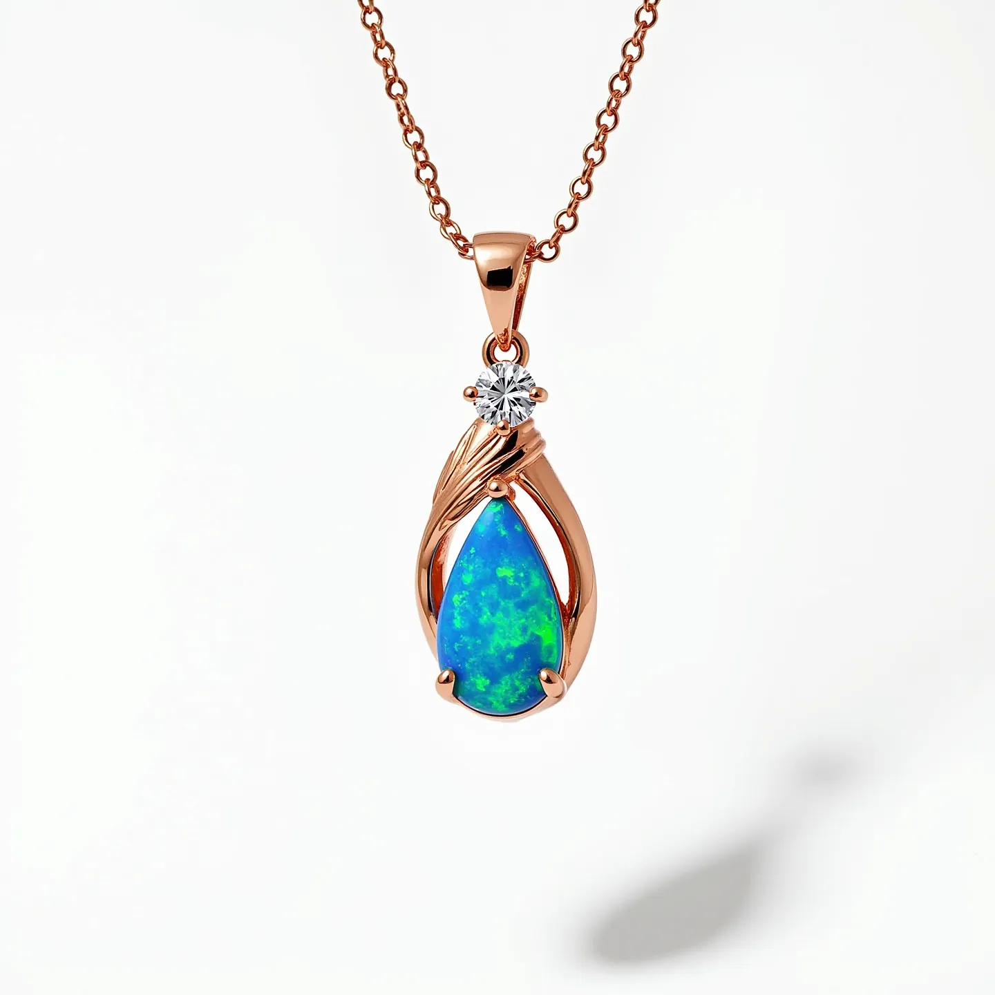 This opal necklace features a vibrant teardrop-shaped opal gemstone exhibiting a play of blue and green hues, enclosed in a rose gold setting with an intricate, swirling design. Accentuating the opal is a brilliant-cut diamond positioned at the top, providing an elegant contrast and additional sparkle. The design is suspended from a delicate rose gold chain, adding to the sophistication of the piece. A classic lobster clasp serves as the attachment, ensuring secure wear while complementing the overall elegance of the necklace.