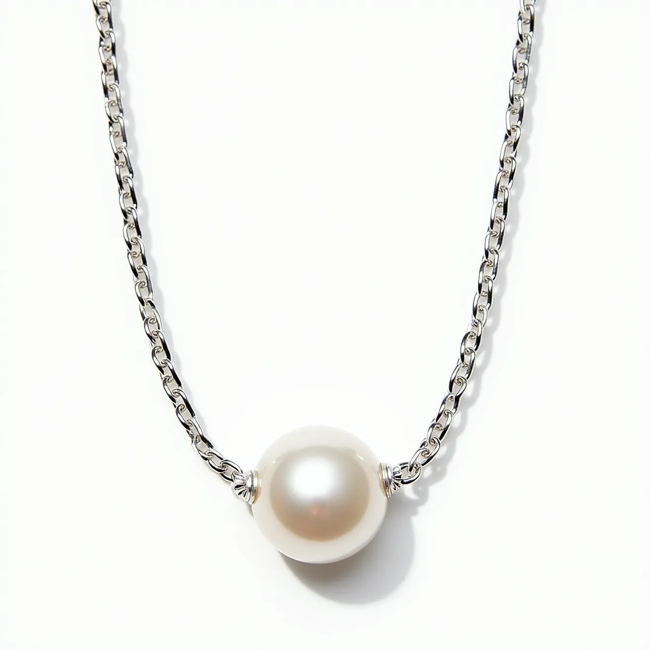 This pearl necklace features a single, lustrous round pearl prominently set as the centerpiece, displaying a classic and elegant look. The pearl is securely held in place by delicate metal settings, which appear to be made from polished silver or a similar metal, enhancing the overall aesthetic with a touch of sophistication. The chain itself is composed of interlocking links, likely made from the same metal as the settings, providing a sturdy yet refined support for the pearl. The combination of the understated chain and the singular pearl creates a timeless piece suitable for various occasions.