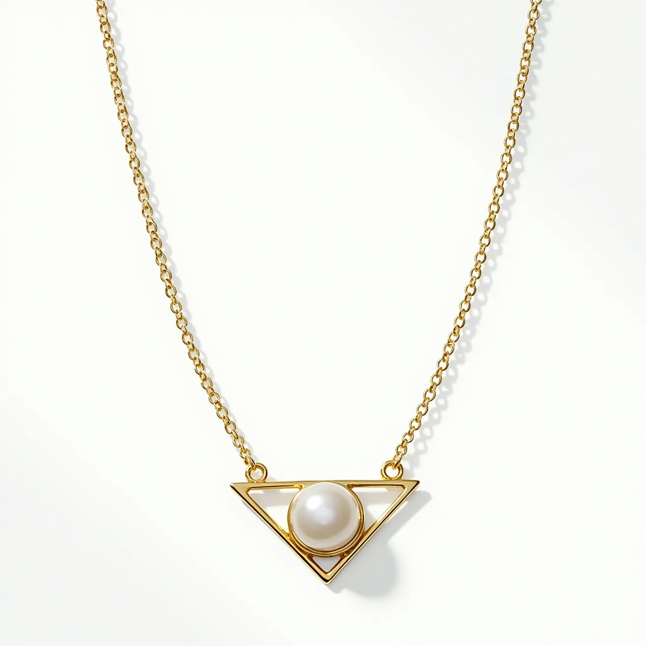 This pearl necklace features a single, lustrous, round pearl set within a geometric triangle pendant. The pearl is centrally positioned in a minimalist open triangle setting, crafted from a gold-toned metal that complements the pearl's sheen. The pendant hangs from a delicate gold chain, which adds elegance and subtlety to the overall design. The necklace likely closes with a classic clasp for secure attachment, ensuring ease of wear. The combination of pearl and gold provides a sophisticated contrast, enhancing the aesthetic appeal of the piece.