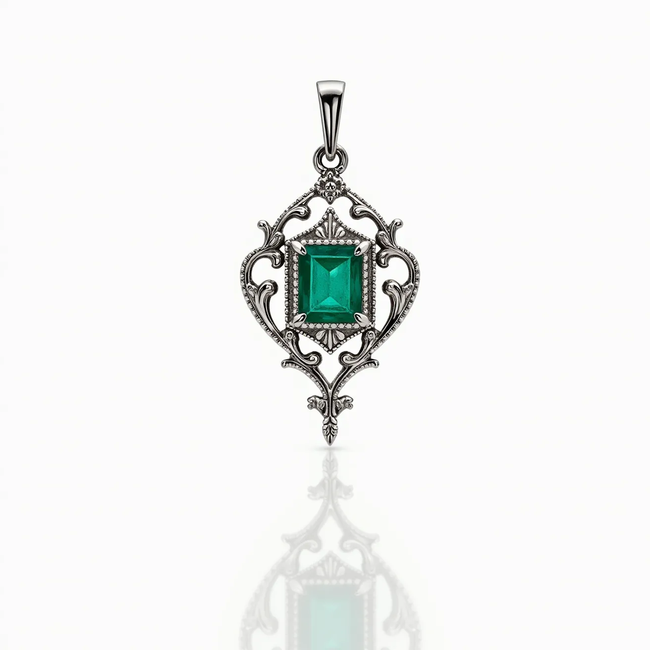 This statement pendant features a striking green, square-shaped gemstone, likely an emerald, set in a sophisticated bezel setting. The gemstone is the focal point of an ornate design crafted from a silver-toned metal that intricately frames the stone with swirling, filigree patterns, giving it an elegant vintage allure. A thin, elongated bail at the top allows for attachment to a chain or necklace, seamlessly integrating with the pendant’s overall design. The harmonious combination of the vibrant gemstone and the detailed metalwork creates a captivating and elegant look, suited for both formal and casual occasions.