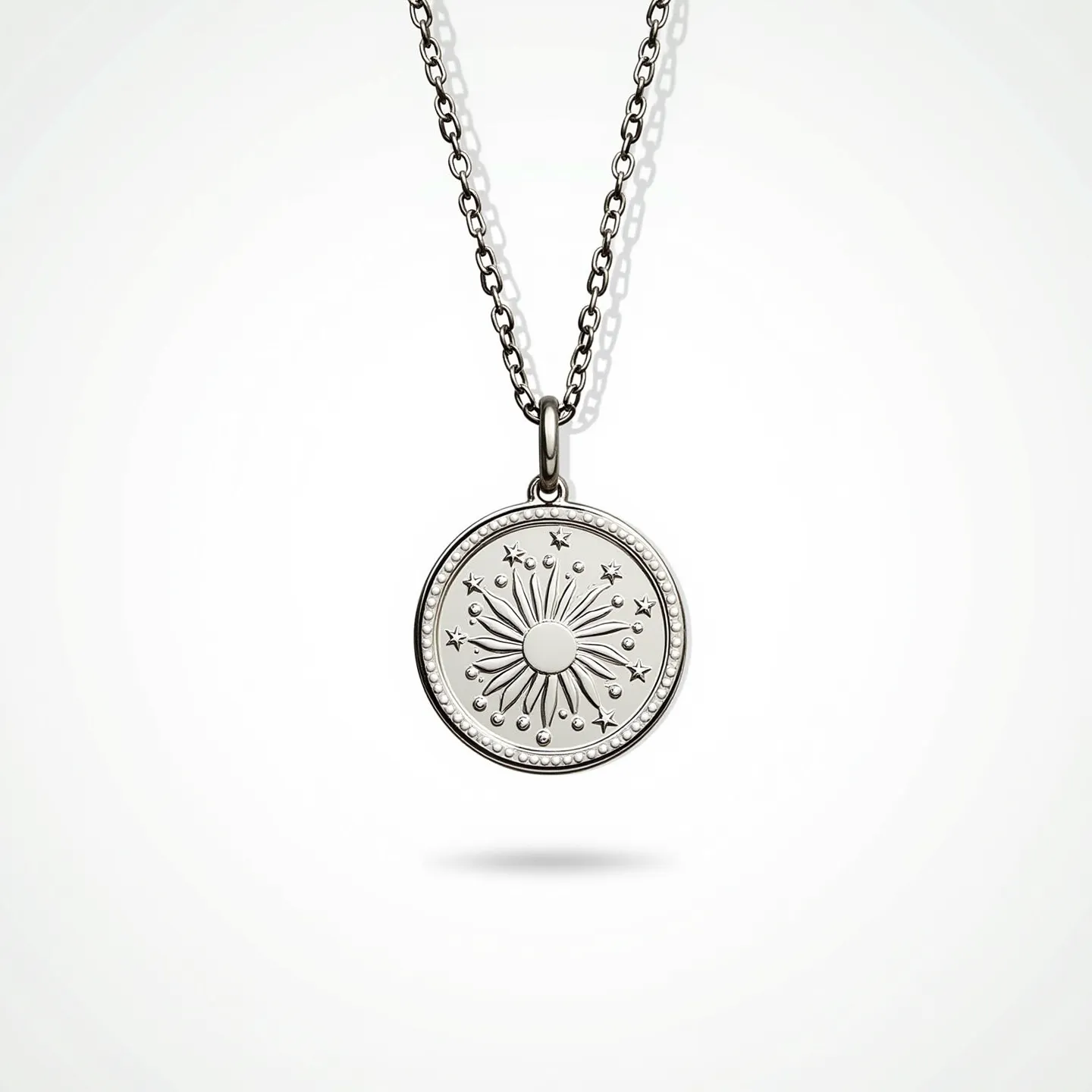 This pendant necklace features a circular metallic pendant, intricately engraved with celestial patterns including stars and a central sun motif, suggesting a cosmic theme. The metal appears to be silver or a similar alloy, lending a polished and reflective finish. The pendant is attached to a classic cable chain through a simple bail. The chain seems to have an adjustable length, allowing for versatile wear, and it likely secures with a traditional lobster clasp, providing both functionality and elegance.