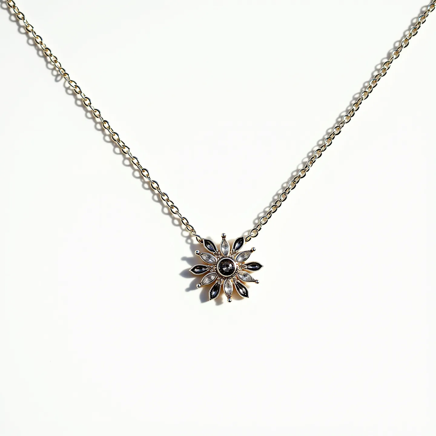 This pendant necklace features a delicate chain, likely crafted from a silver or white gold material, offering a sleek and elegant look. The pendant itself is designed in a floral motif with a central round gem set into the middle, possibly a dark stone like onyx or a black diamond, surrounded by a halo of marquise-cut stones that resemble petals, alternating in a contrasting hue, possibly a lighter gemstone like white sapphires or diamonds. Each stone is set in a prong setting, enhancing their visibility and brilliance. The necklace is completed with a standard clasp, ensuring both security and ease of use.