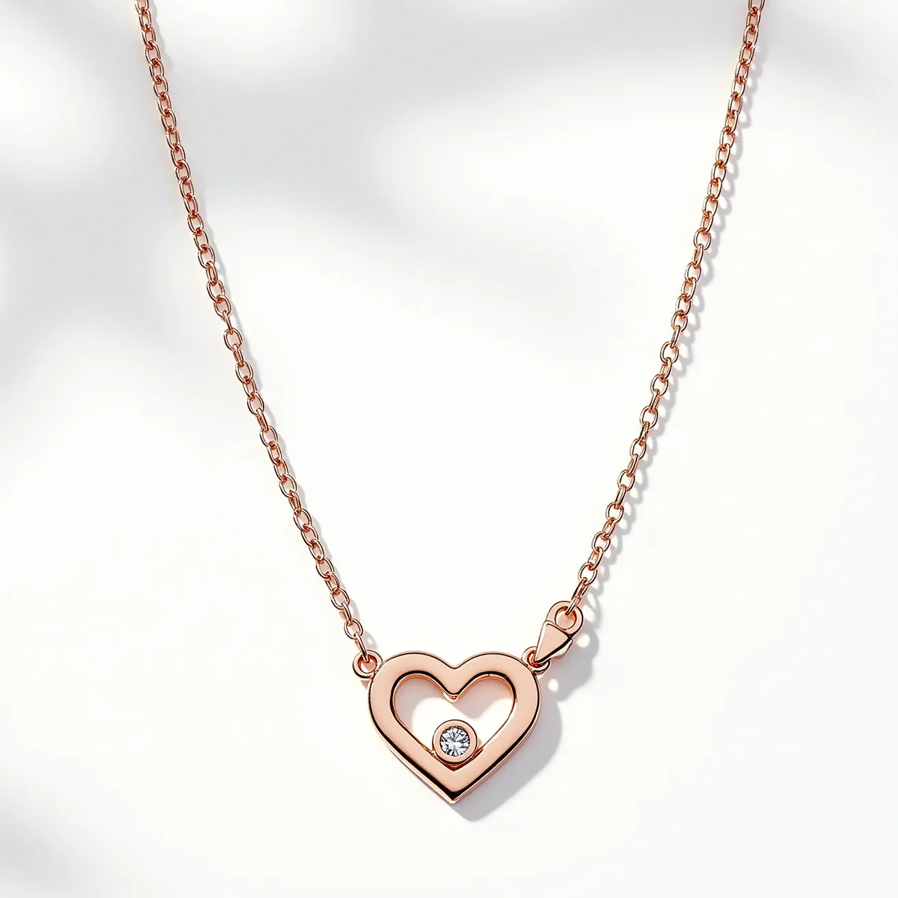 This pink heart necklace features a delicate pendant crafted from rose gold, giving it a soft, romantic hue. At its center, the heart pendant is adorned with a single round-cut diamond set flush within the design, adding a subtle sparkle. The pendant is attached to a fine chain, providing an elegant and seamless look. The necklace is secured by a simple and functional clasp, ensuring it stays comfortably in place when worn. The combination of rose gold and diamond makes this piece both timeless and fashionable.