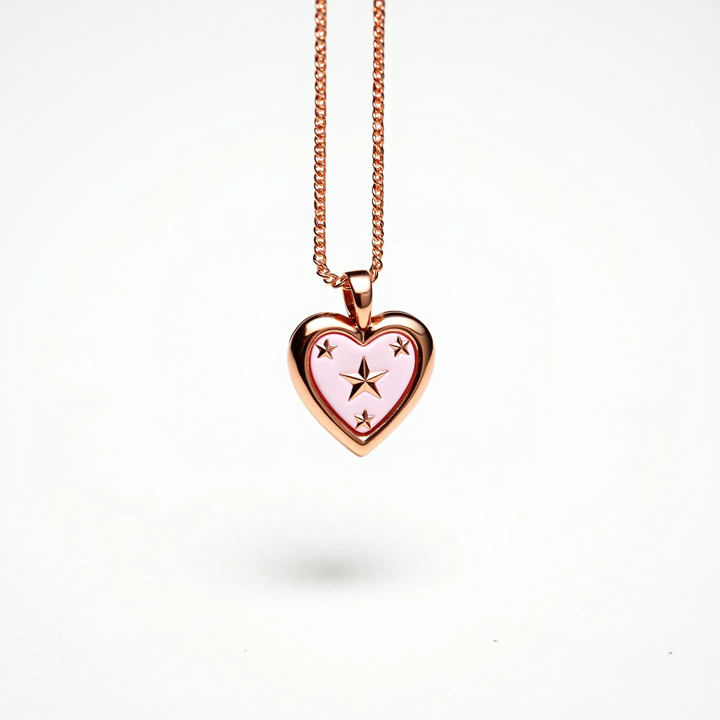 This pink heart necklace features a pendant with a softly rounded heart shape bordered by a warm, rose gold metal. The central area is filled with a smooth pink enamel, set with star motifs that appear to be crafted from the same rose gold material, creating an intricate design. The pendant is suspended from a finely crafted chain, also made of rose gold, which is characterized by its tightly interlinked structure. The attachment of the pendant to the chain is facilitated by a smooth, integrated bail that seamlessly connects to the necklace, ensuring a cohesive and elegant appearance.