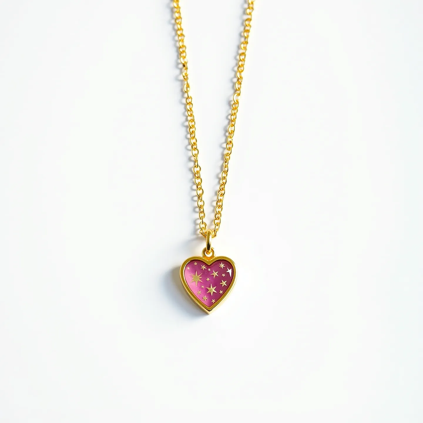 This pink heart necklace features a gold-toned chain, likely made of a metal such as gold or a gold-plated material, providing a lustrous and elegant appearance. The pendant is heart-shaped with a vivid pink center adorned with small star designs, giving it a whimsical and romantic touch. The heart appears to be encased in a polished gold-toned setting that complements the chain. The necklace is attached with a simple loop at the top of the pendant, connected to the chain, which likely includes a standard clasp for secure fastening around the neck.