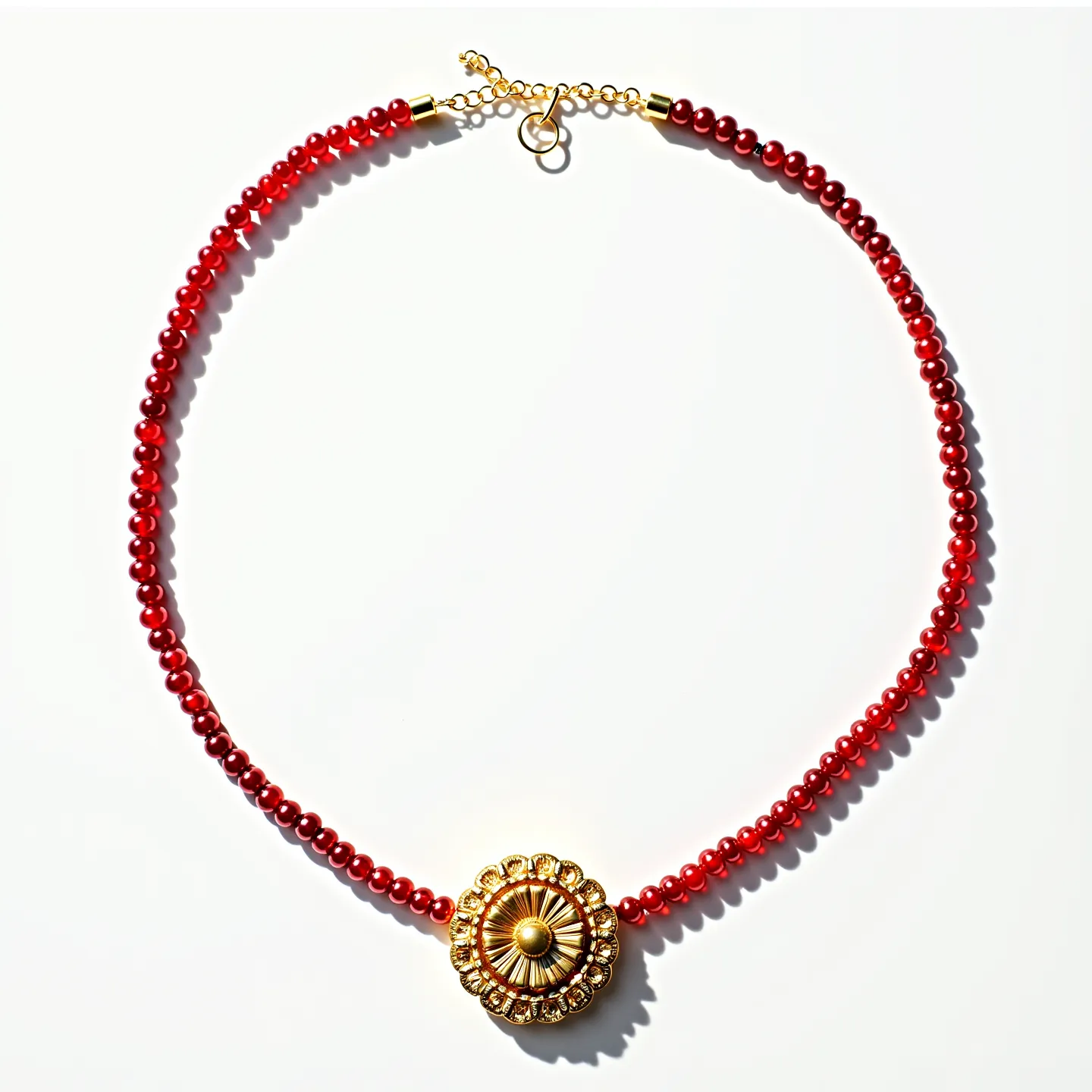 This red necklace features a string of polished red beads, each uniformly rounded and contributing to the necklace's vibrant appearance. At the center, there is a prominent circular gold pendant, adorned with intricate detailing that includes a sunburst pattern accented by small, clear stones set around its perimeter. The beads and the central pendant work together to create a striking visual contrast. The necklace is secured by a gold-toned clasp with an adjustable chain, allowing for a flexible fit. The overall design blends elegant materials and craftsmanship, resulting in a piece that is both eye-catching and versatile.