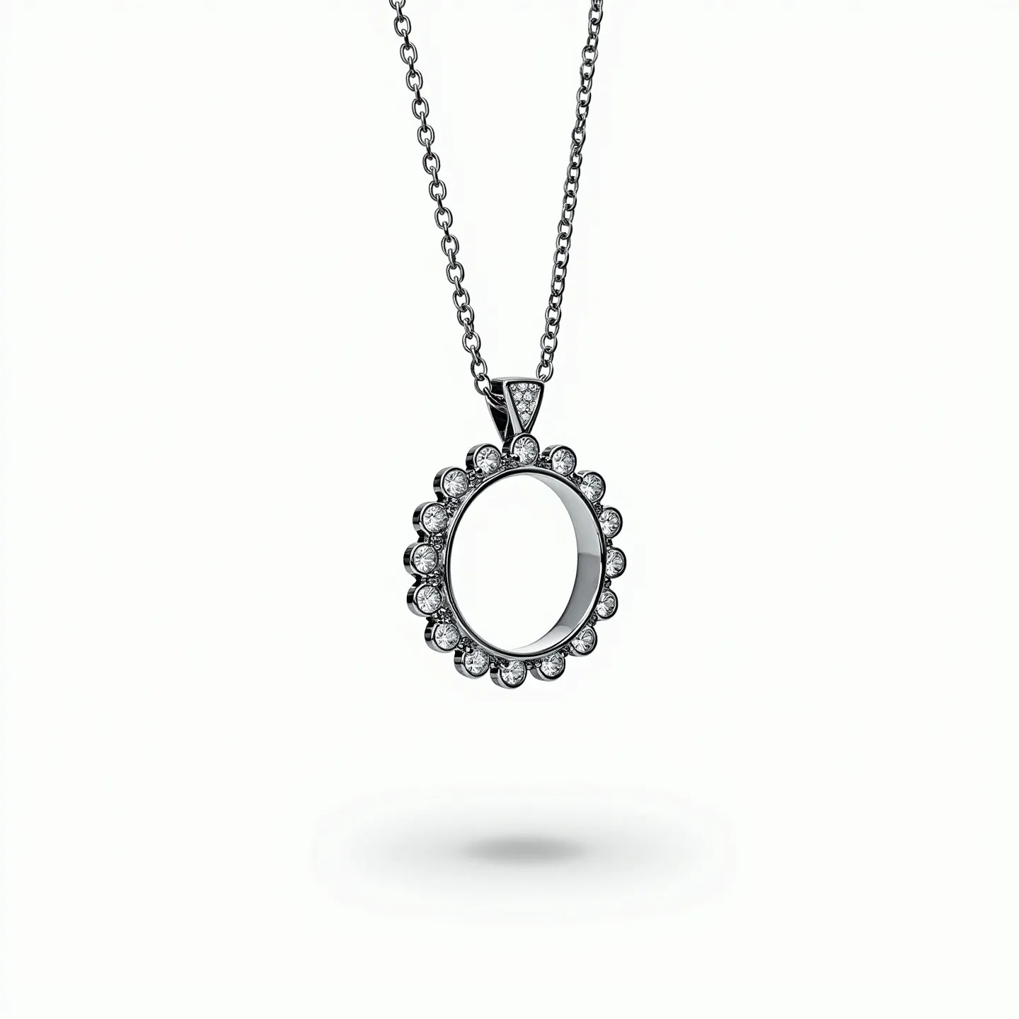 This ring necklace features a circular pendant adorned with small, round-cut gemstones, each set in a secure bezel setting that forms a scalloped edge design. The pendant appears to be crafted from a polished metal, which could be silver or white gold, giving it a sleek and reflective finish. Suspended from a delicate chain, this necklace has a subtle and seamless attachment point at the top of the pendant. The chain itself is composed of small, interlocking links, likely made from the same material as the pendant, ensuring a cohesive and elegant appearance.