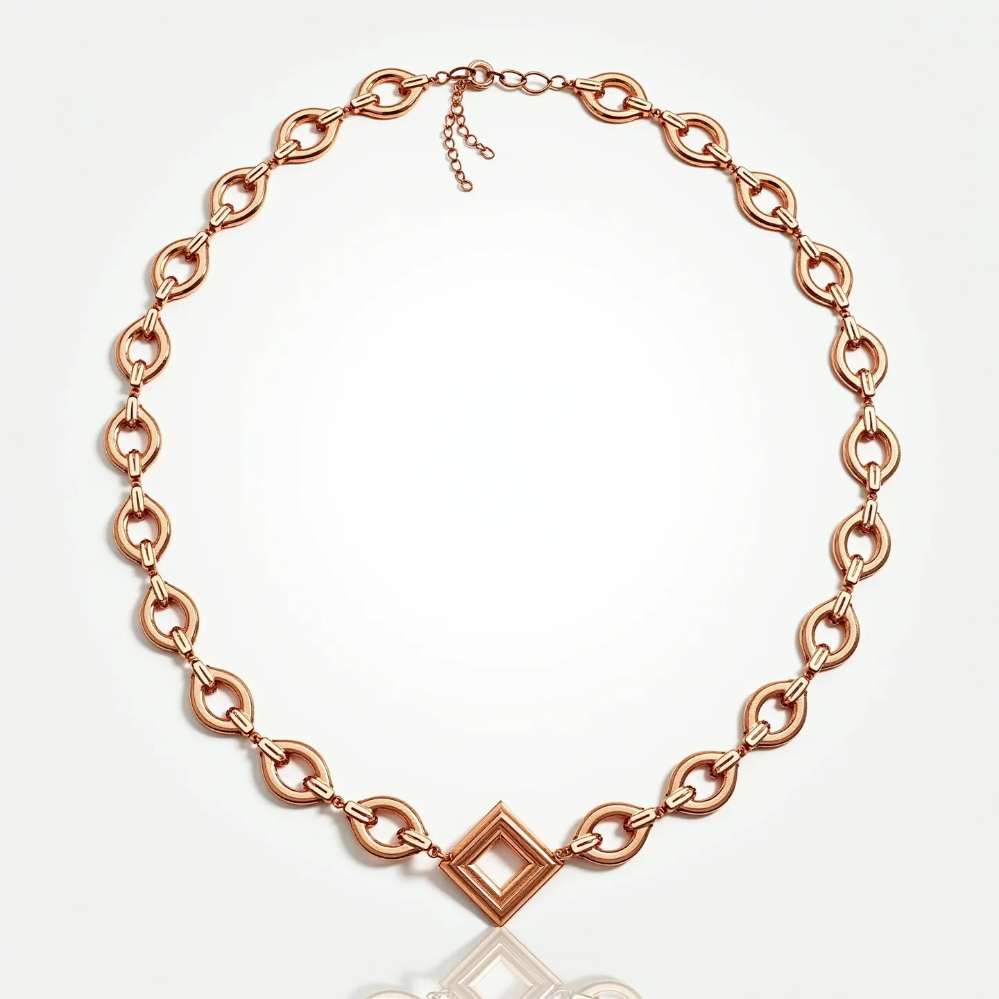 This rolo chain necklace features interlocking circular links crafted from a warm, rose-gold material, giving it an elegant and polished appearance. At its center, the necklace is adorned with a distinctive geometric focal point in the shape of a double-layered square frame, adding a modern and artistic flair to the design. The necklace is equipped with an adjustable chain and clasp mechanism, allowing for flexibility in length and ensuring a secure fit when worn. The meticulous construction and choice of material reflect a combination of contemporary style and classic design, making it a versatile piece suitable for various occasions.