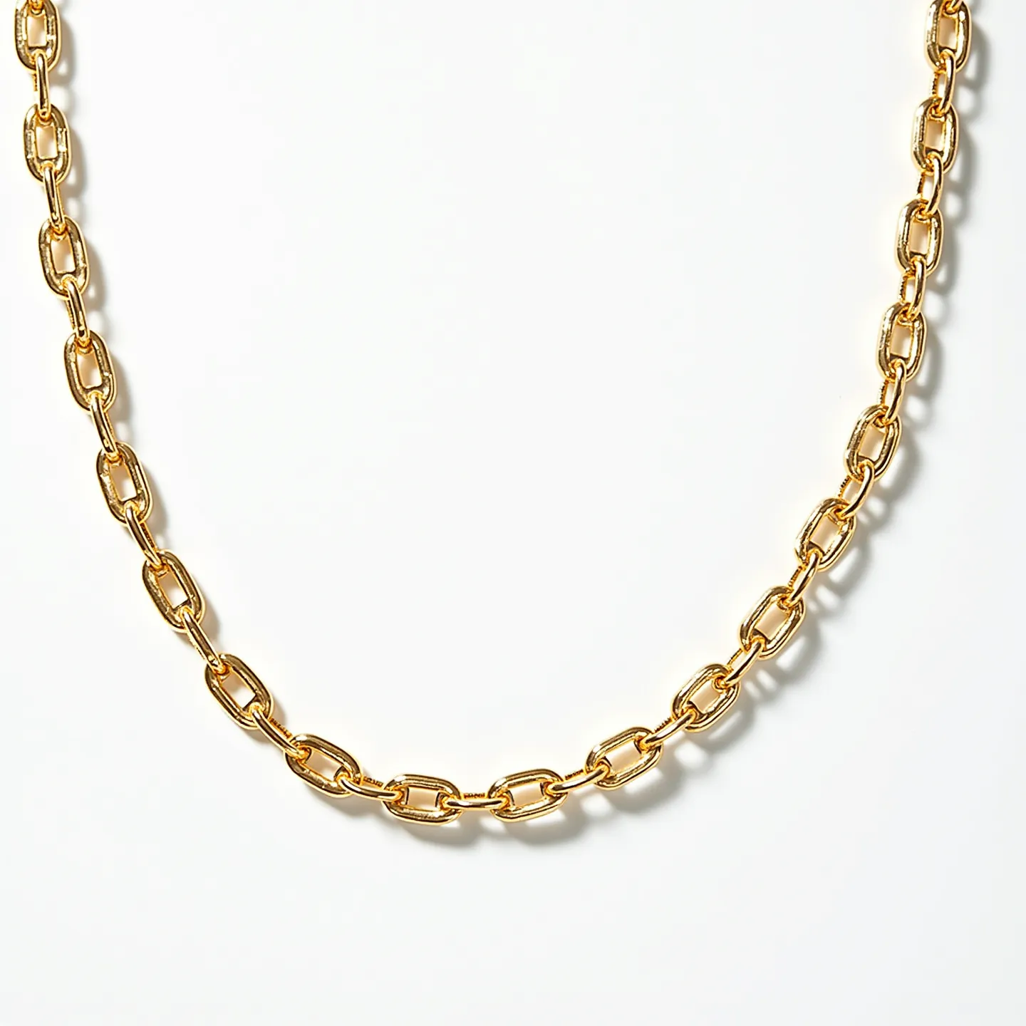 This rolo chain necklace features interlocking round links crafted from a polished gold-toned material, giving it a classic and elegant appearance. The links are uniform in size, creating a consistent, flowing design throughout the length of the necklace. There are no visible attachments or stones embedded within this design, maintaining a simple yet sophisticated aesthetic. The necklace likely includes a standard clasp, possibly a lobster or spring ring, to ensure secure fastening and ease of wear.