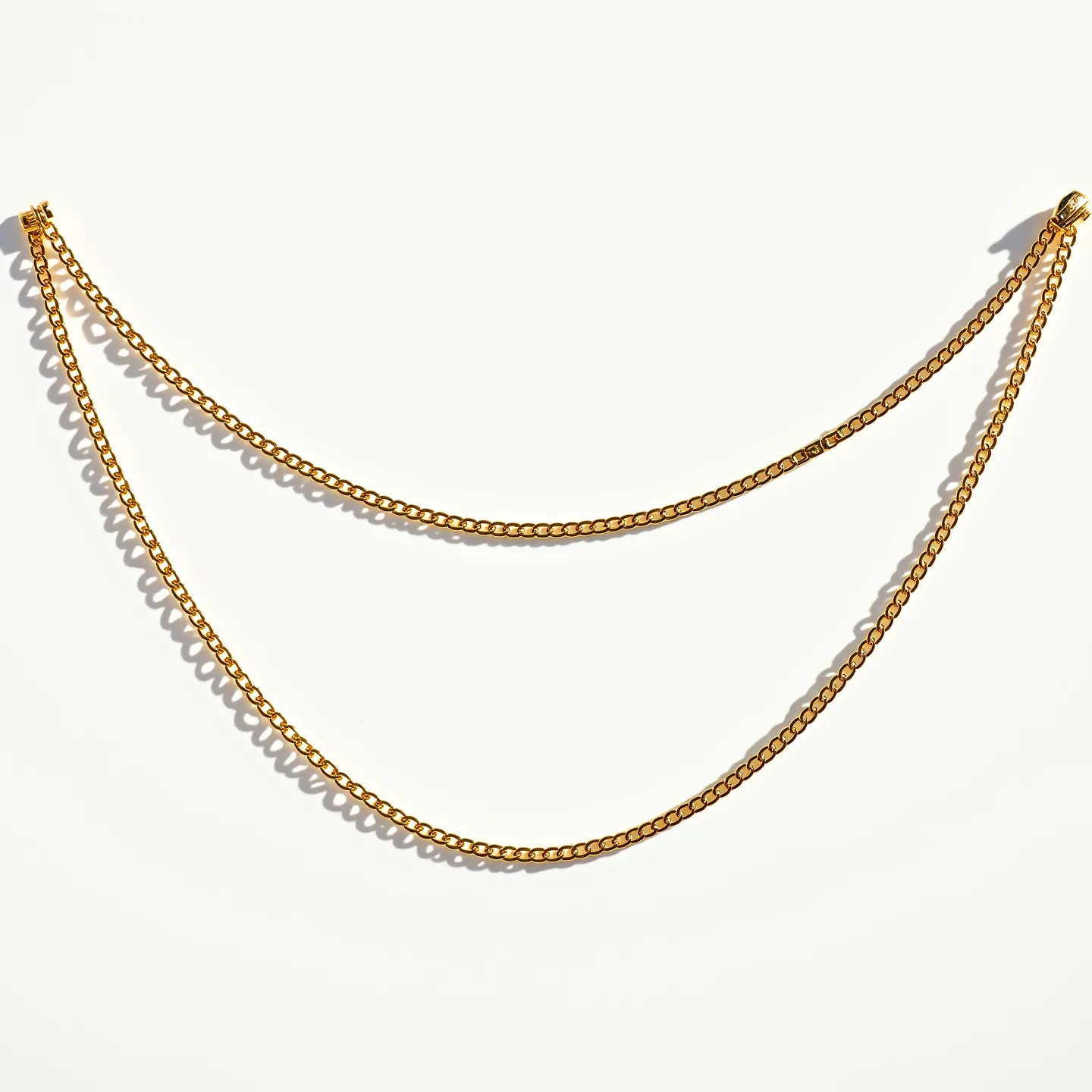 This rolo chain necklace features circular, interlocking links made of a gold-toned metal, giving it a classic and elegant appearance. The uniformly sized links create a smooth and continuous flow, enhancing its simplicity and versatility. The chain is fitted with a lobster claw clasp, providing secure and easy wearability. Its overall design reflects understated sophistication, making it suitable for both casual and formal occasions.