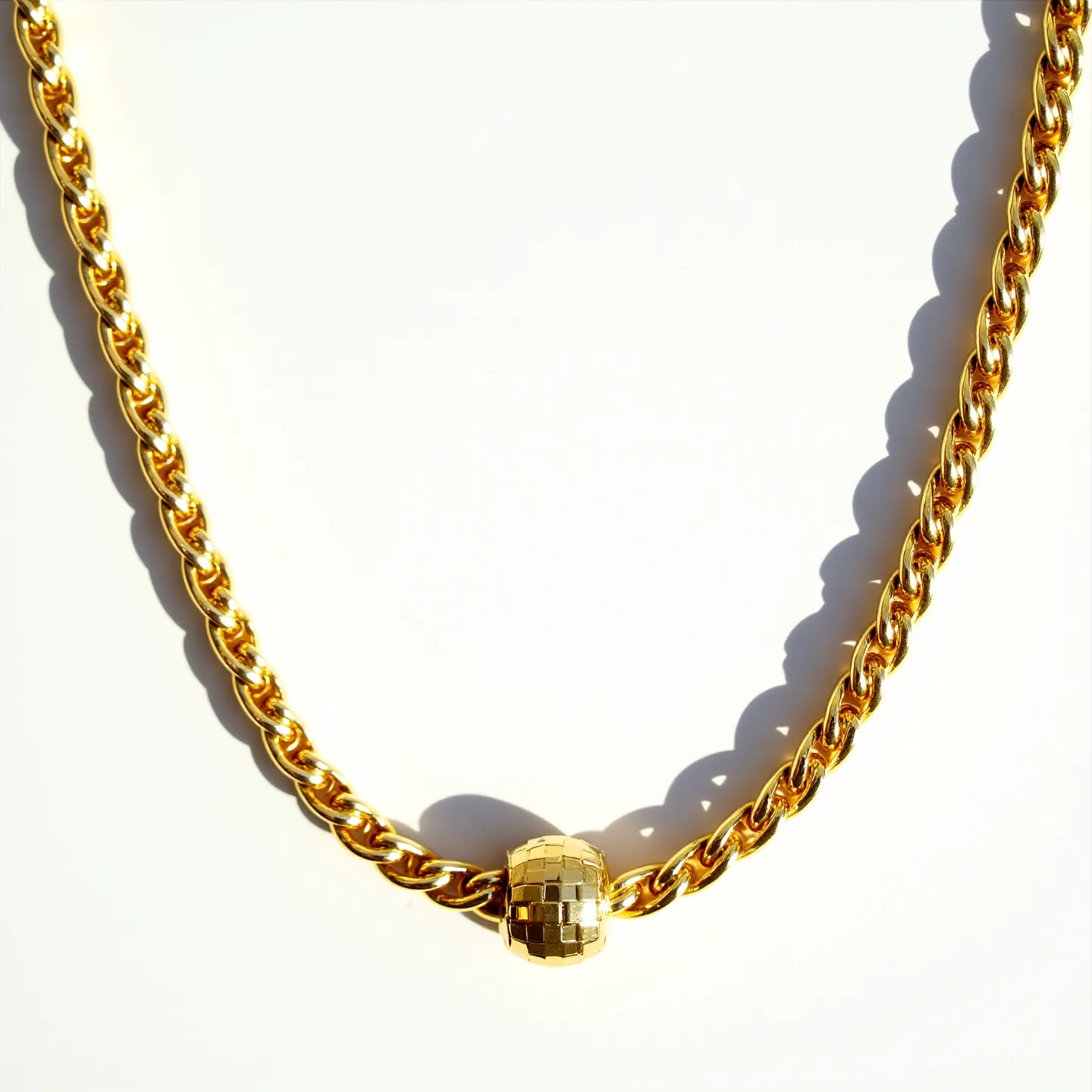 This rope chain features a classic twisted design, likely crafted from yellow gold, giving it a warm and luxurious appearance. It is adorned with a spherical charm that has a faceted pattern, adding a decorative and reflective quality to the piece. The chain’s links are tightly woven, creating a sturdy but elegant aesthetic, and it terminates in a rounded element that seems to securely anchor the charm. The overall craftsmanship suggests a focus on both durability and style, making it suitable for both everyday wear and special occasions.