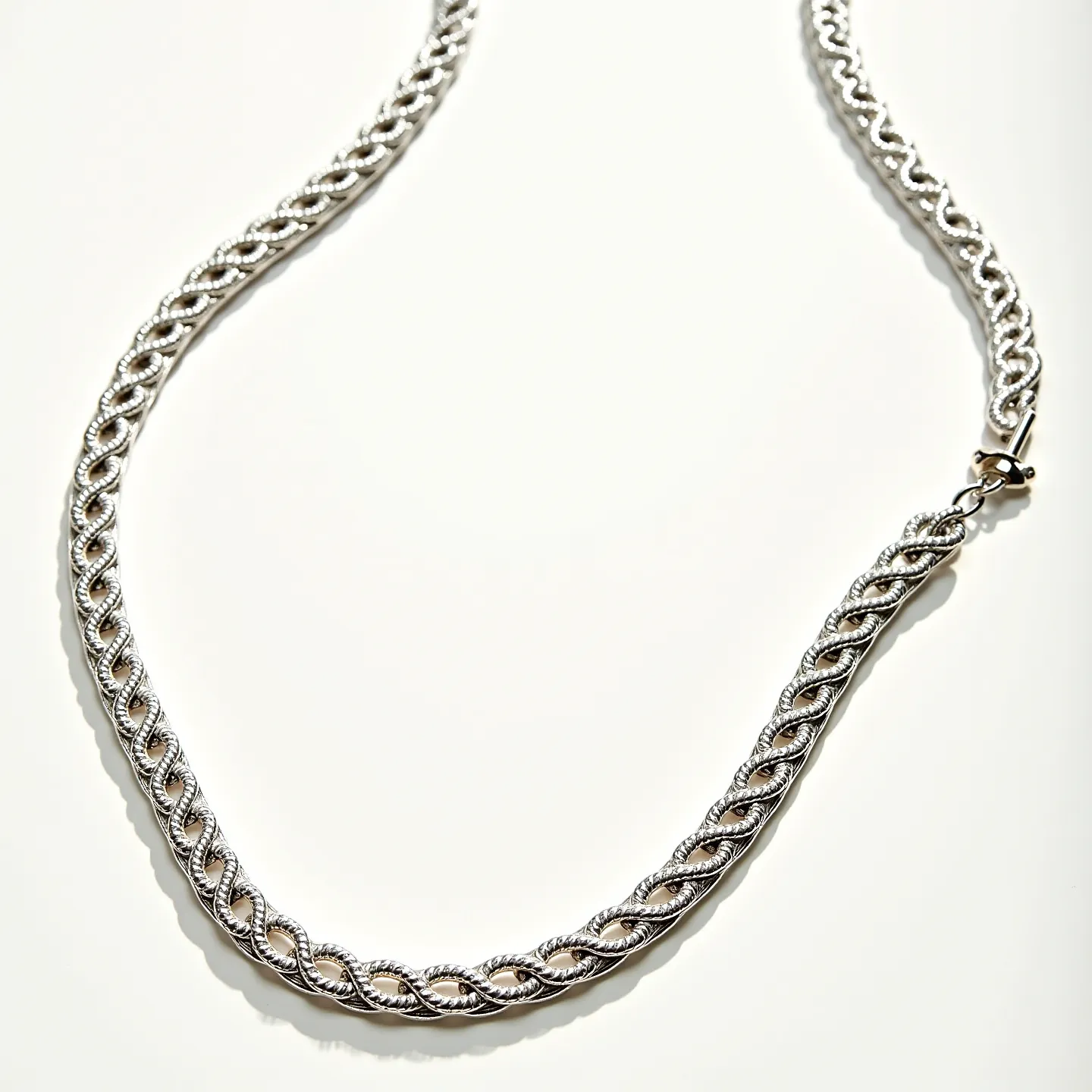 This rope chain features intertwined links that create a twisted, intricate design, typically crafted from a metal such as silver or white gold to give it a polished, reflective finish. The chain is devoid of any gemstones, focusing instead on the elegance of the rope pattern itself. It is secured with a lobster clasp, ensuring a sturdy and reliable attachment. The overall look is classic and versatile, suitable for both casual and formal wear.