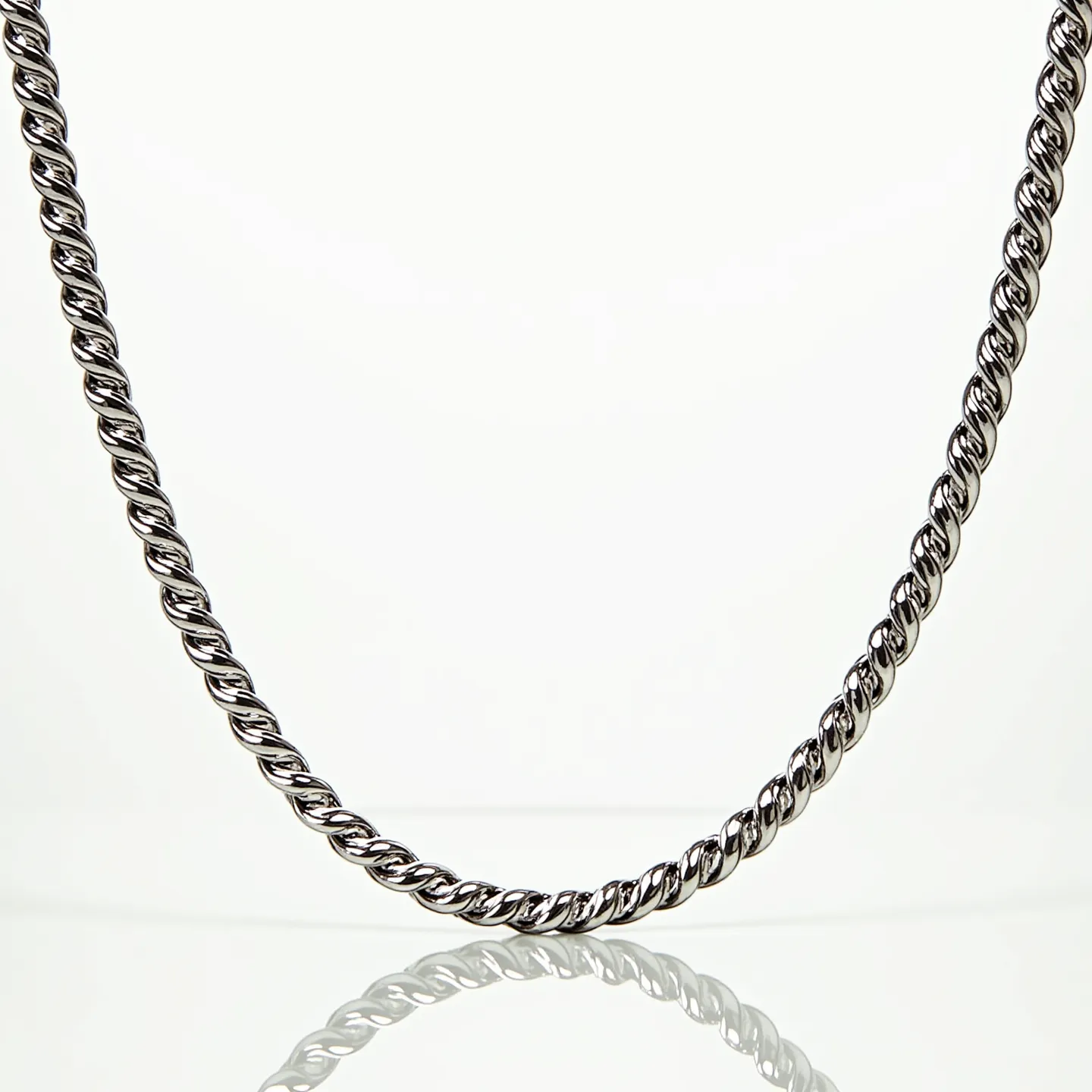 This rope chain features an intricate twisted design typical of rope chains, which appear to be composed of a polished, metallic material, likely silver or white gold. The twisting pattern adds texture and reflects light, creating a shimmering appearance. The chain appears uniform and robust, suggesting durability. There are no visible gems or stones set within the chain, and the focus is on the sleek metallic design. The chain likely includes a secure clasp or attachment to ensure it can be worn securely, though specific details about the clasp are not visible.