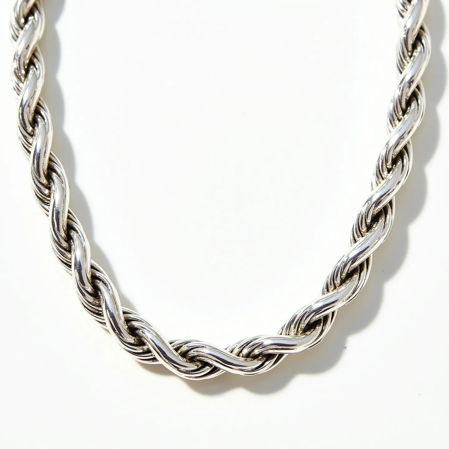 This rope chain features an intricately twisted design, crafted from a lustrous silver material that reflects light beautifully, giving it an elegant sheen. It showcases a classic rope pattern, with multiple strands intertwining closely, creating a durable yet flexible piece. The metallic finish suggests a high-quality silver or a silver-like alloy construction. There are no visible stones or gemstones integrated into the chain. The chain likely includes a secure clasp for closure, ensuring ease of wear and a seamless, continuous appearance when fastened.