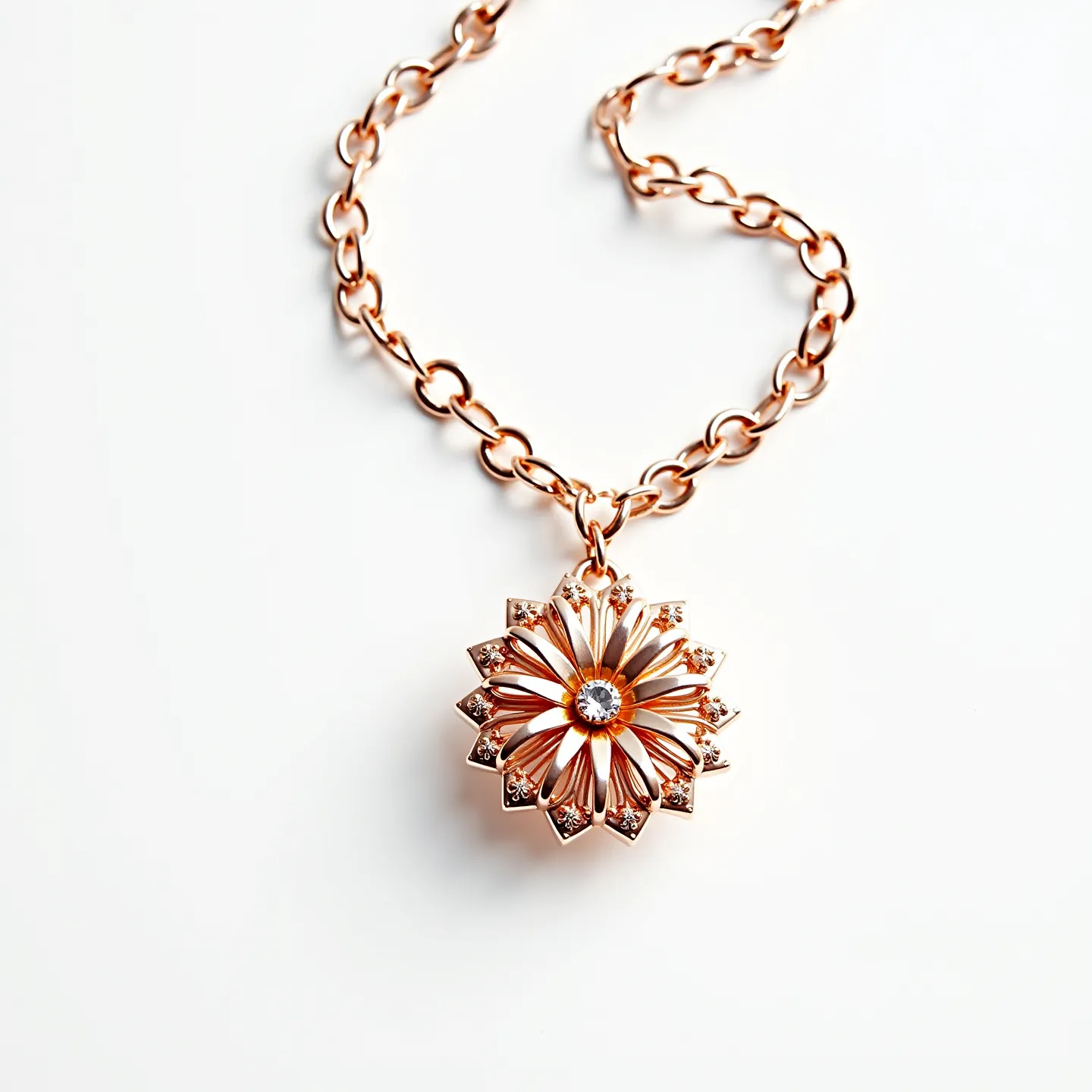 This rose gold necklace features a delicate chain with medium-sized links, giving it a modern and elegant appearance. Suspended from the chain is a striking pendant with a floral design, adorned with a central round gemstone, possibly a diamond, set in a bezel setting. Surrounding this center stone are petals set with tiny stones, adding a touch of sparkle and complementing the rose gold hue. The overall design showcases a harmonious blend of elegance and artistry, making it a standout piece.