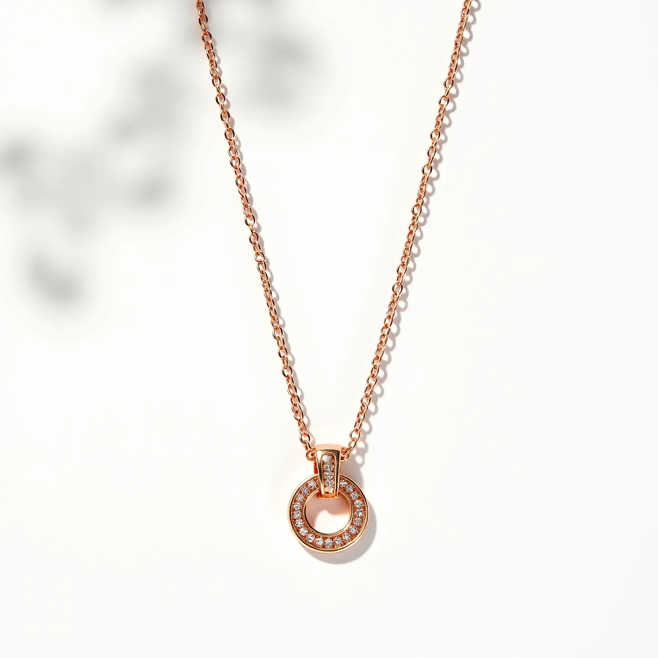 This rose gold necklace features a delicate chain crafted from rose gold, accentuating its warm, elegant tone. The pendant is a circular design, encrusted with small, round-cut gems, likely diamonds, that add a touch of sparkle. The diamonds are neatly set in a pavé setting, emphasizing the round shape of the pendant. Attached through a clearly integrated bail, the pendant hangs gracefully, allowing the gemstones to catch the light beautifully. The necklace is completed with a secure clasp, ensuring ease of wear and a seamless finish to the design.