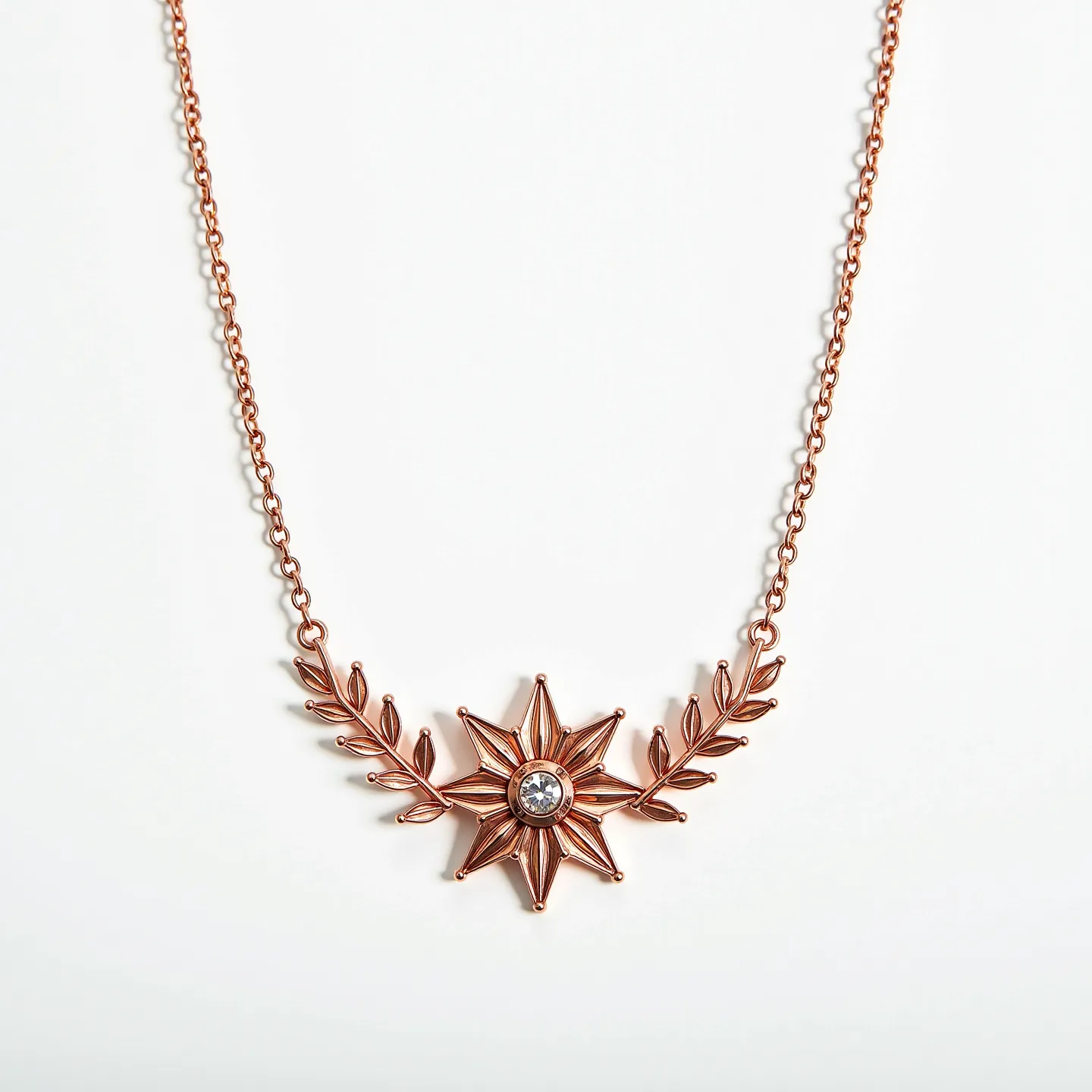 This rose gold necklace features an intricate design with a central star-shaped motif embellished with a single round-cut gemstone, likely a diamond or crystal, set securely at its center. The star is flanked by stylized leaf designs, seamlessly integrated into the rose gold chain, adding an elegant nature-inspired touch. The necklace closes with a subtle lobster clasp that blends with the overall aesthetic, ensuring both security and style. This piece artfully combines modern elegance with a touch of whimsy, making it a versatile accessory for various occasions.