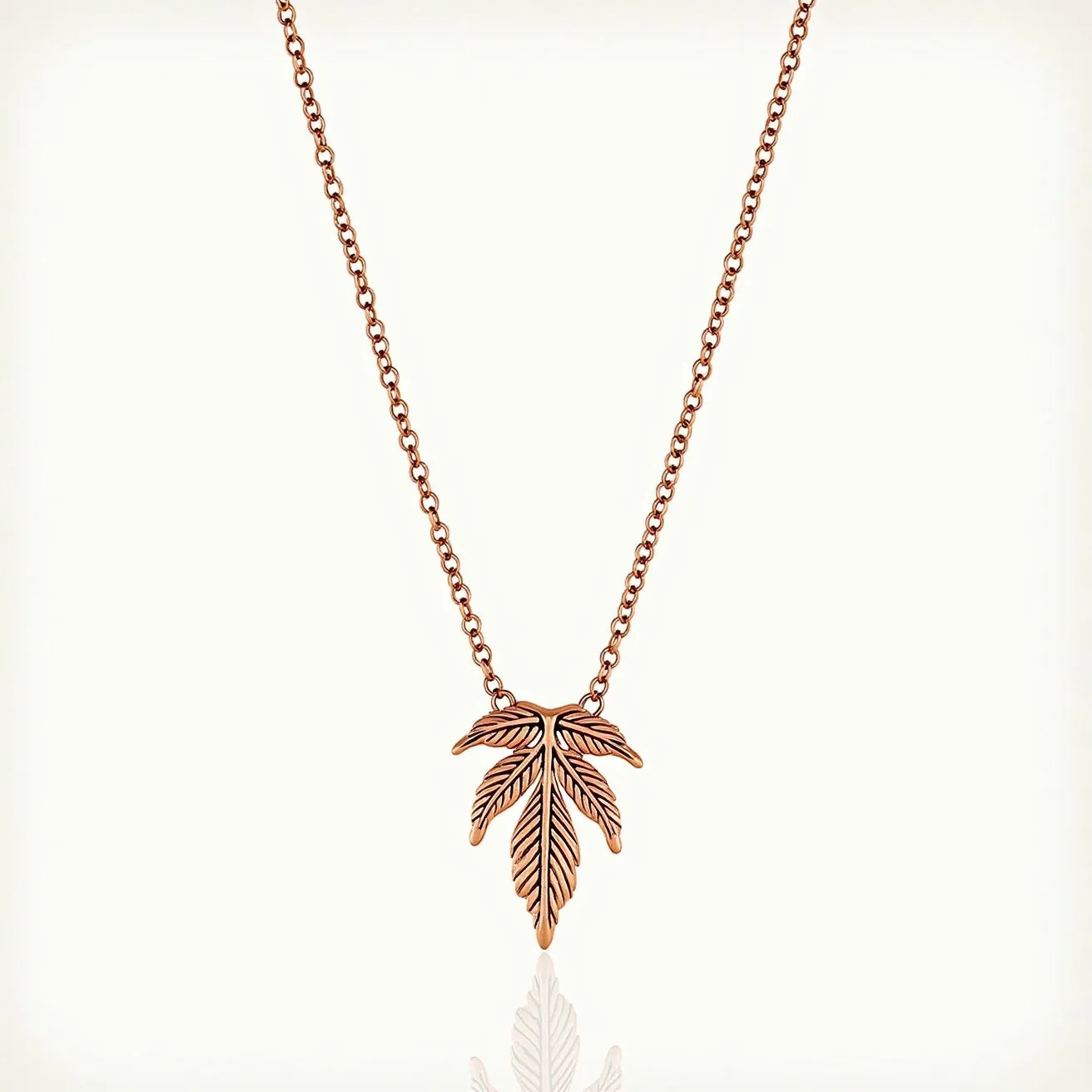 This rose gold necklace features a delicate chain that supports an intricately designed leaf pendant, emphasized by its detailed veins and polished finish. The pendant hangs elegantly from the chain, showcasing the beauty of the rose gold material. The chain likely includes a standard clasp mechanism, allowing for secure attachment. The design's simplicity and elegance make it a versatile piece suitable for a variety of occasions.