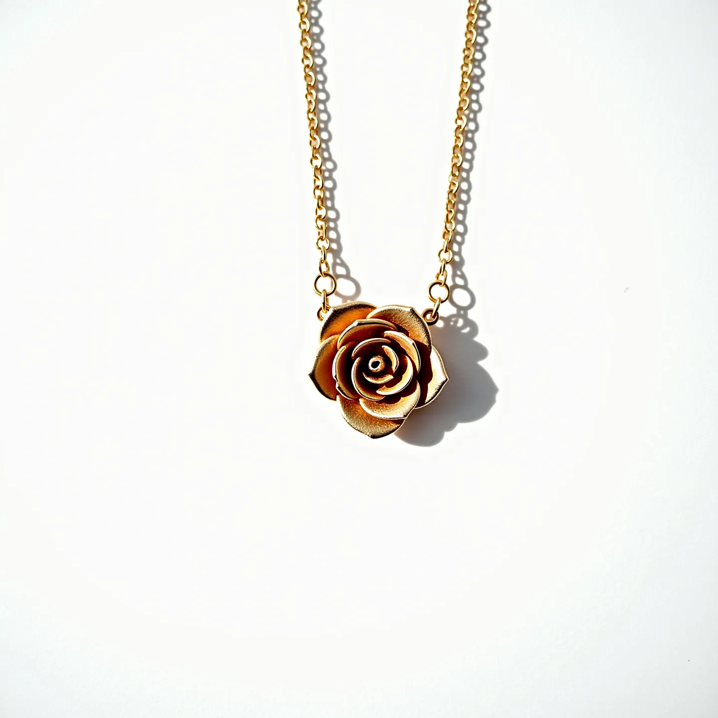 This rose necklace features a delicately crafted rose pendant that appears to be made of metal, possibly gold or gold-toned, showcasing intricate petal details. The rose is affixed to a fine chain that complements the pendant's color and material. The necklace includes standard chain links leading to a clasp, which is likely a simple spring-ring or lobster clasp, ensuring secure wear. The design focuses on the elegant form of the rose, highlighting its artistic and decorative appeal without additional gems or stones.