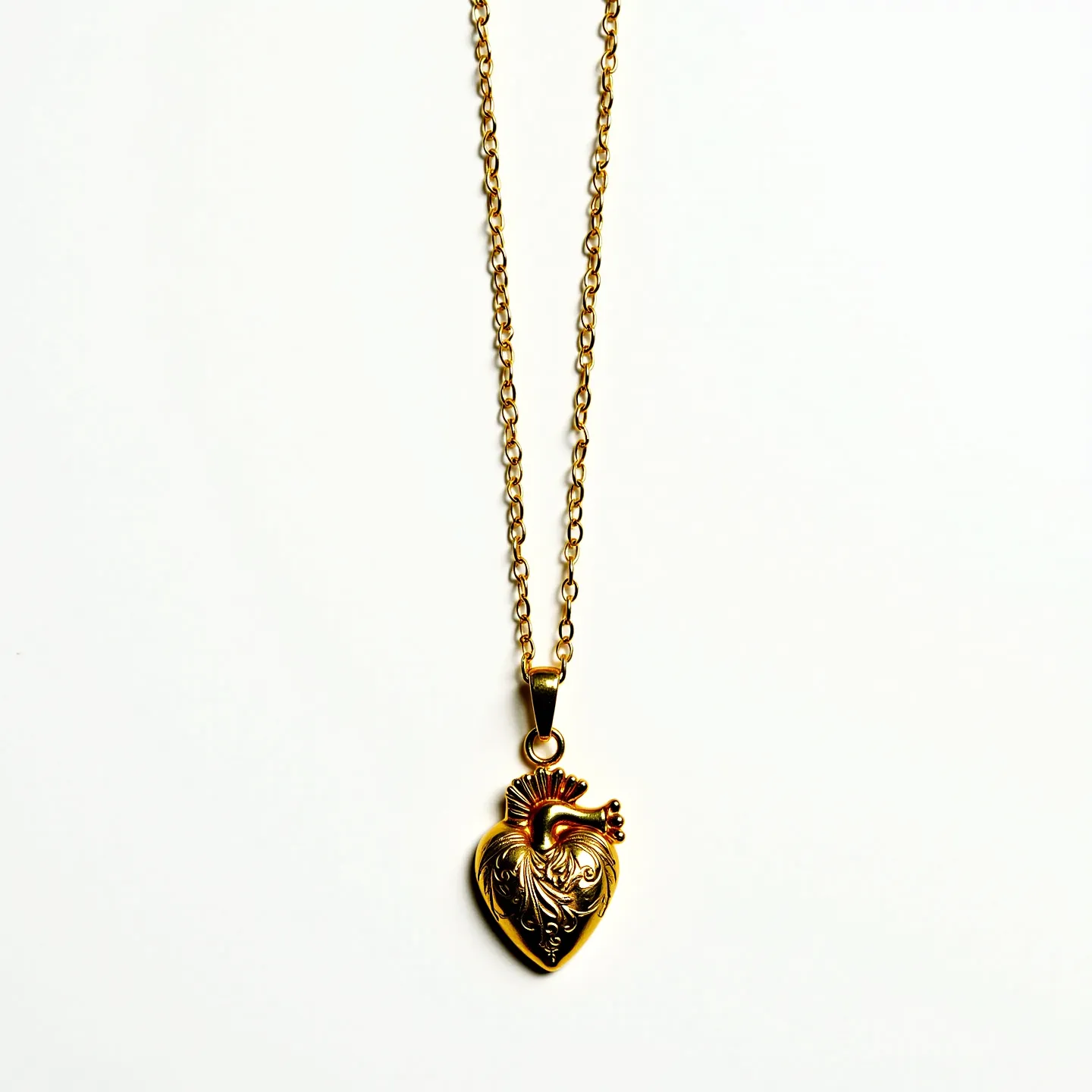 This sacred heart necklace features a beautifully detailed pendant crafted from gold-toned metal. The pendant showcases an ornate design of the sacred heart motif, highlighted by intricate engravings and a flame crown at the top. The pendant hangs gracefully from a matching gold-toned chain, secured with a classic lobster clasp for easy attachment. The overall design embodies both elegance and spiritual symbolism, making it a meaningful accessory.