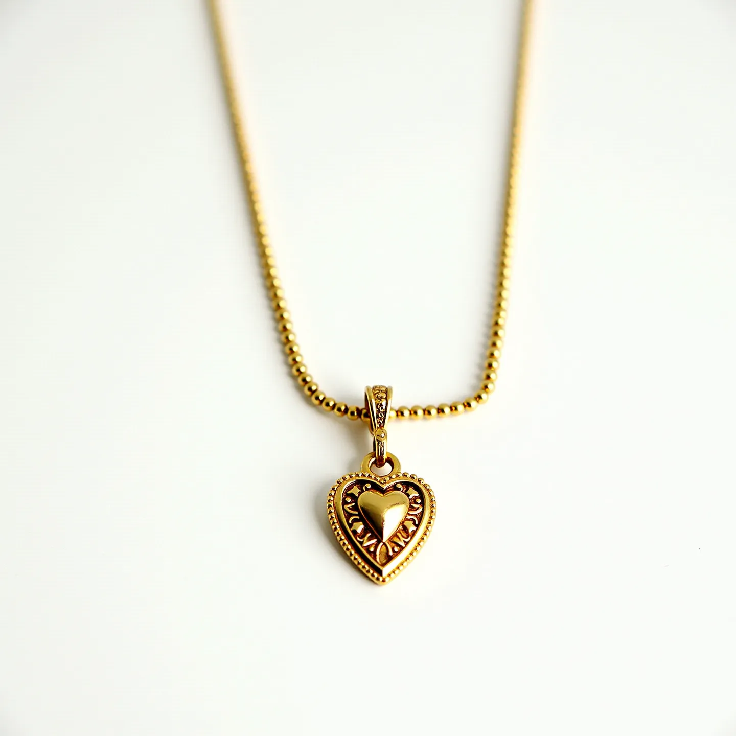 This sacred heart necklace features a delicate gold chain that supports a beautifully crafted pendant. The pendant is a gold heart with intricate detailing and is surrounded by a border that adds depth and elegance. The central heart motif is polished to a high shine, creating a striking contrast with the textured elements of the design. The necklace is completed with a secure clasp that ensures ease of wear while maintaining its aesthetic appeal. The overall design reflects both sophistication and devotion, making it a memorable piece.