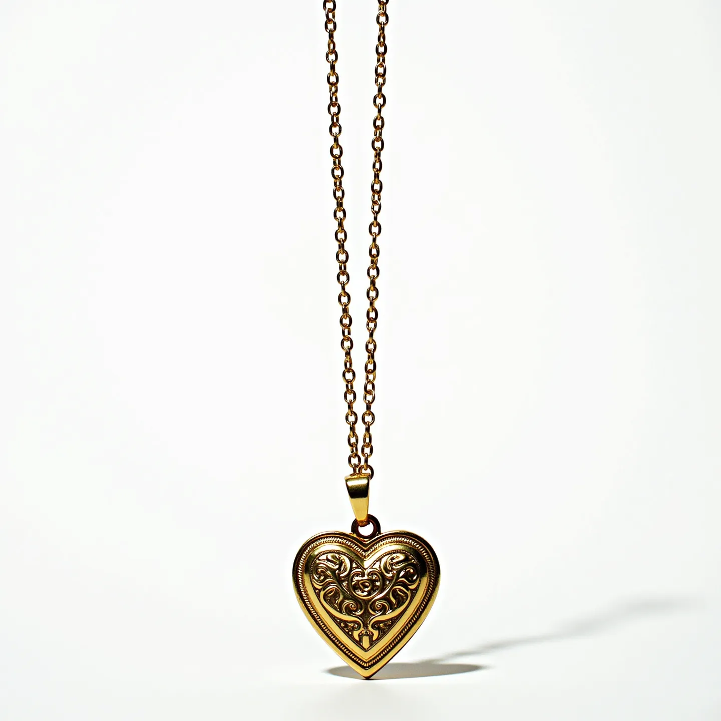 This sacred heart necklace features a beautifully crafted heart-shaped pendant made of gold-toned metal, adorned with intricate scrollwork patterns on its surface. The delicacy of the design enhances the charm and elegance of the piece. The pendant is suspended from a matching delicate chain, linked with small, uniform loops, and attached with a simple but secure clasp. The necklace exudes a timeless and classic appeal, making it a meaningful and cherished accessory.