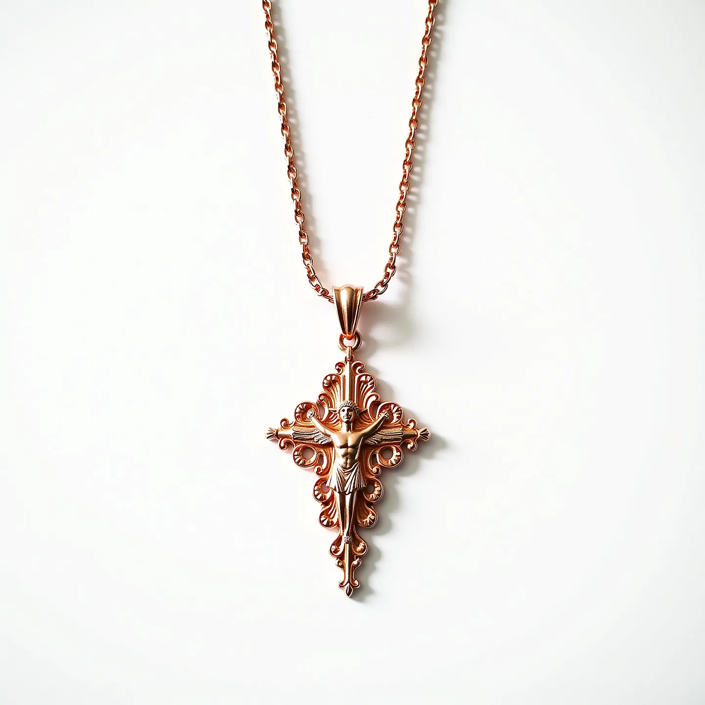 This Saint Michael necklace features a finely crafted pendant made of rose gold-toned metal, depicting a detailed image of Saint Michael set against an ornate and intricate cross background. The pendant is suspended from a matching rose gold chain that has a simple, yet elegant design, contributing to the overall harmony of the piece. The chain appears to have a traditional link style, providing both strength and aesthetic appeal. The necklace is designed with a secure clasp that ensures ease of wearing and removal while complementing the rest of the piece. The combination of the detailed metalwork and the warm hue of the material makes this necklace a striking accessory.