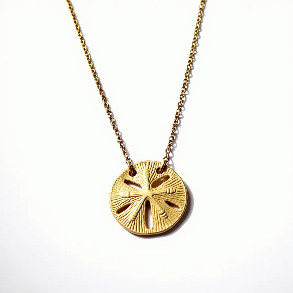 This sand dollar necklace features a gold-toned pendant intricately designed to resemble a sand dollar with detailed texture and cutouts. The pendant is suspended from a delicate chain, likely made of a similar gold-toned material. The chain consists of small, interlocking links, lending it a refined and elegant appearance. The attachment of the pendant to the chain is seamless, ensuring the pendant remains the focal point of the piece. This necklace is likely secured with a standard lobster clasp, providing both functionality and ease of use.