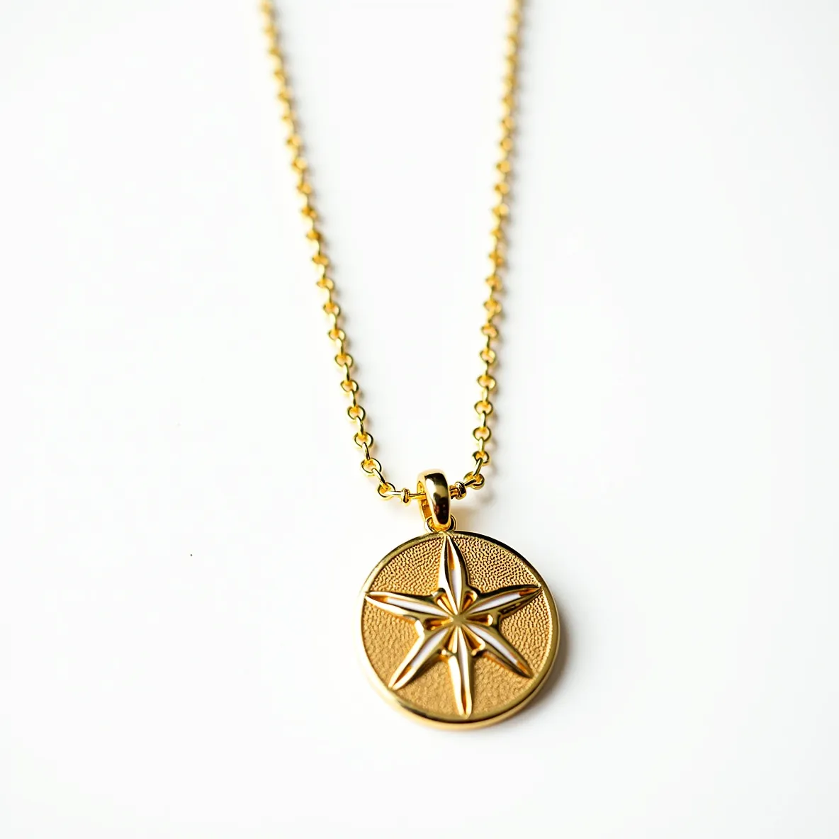 This sand dollar necklace features a gold-tone pendant crafted to resemble the distinct pattern of a sand dollar, with a star-like motif at its center. The pendant is suspended from a delicate, matching gold-tone chain composed of small, uniform links. It is attached via a smooth, polished bail that complements the overall design. While there are no visible gems or stones incorporated into the piece, its metallic sheen adds elegance and a touch of sophistication. The necklace likely secures with a typical clasp, but it is not visible in the image.