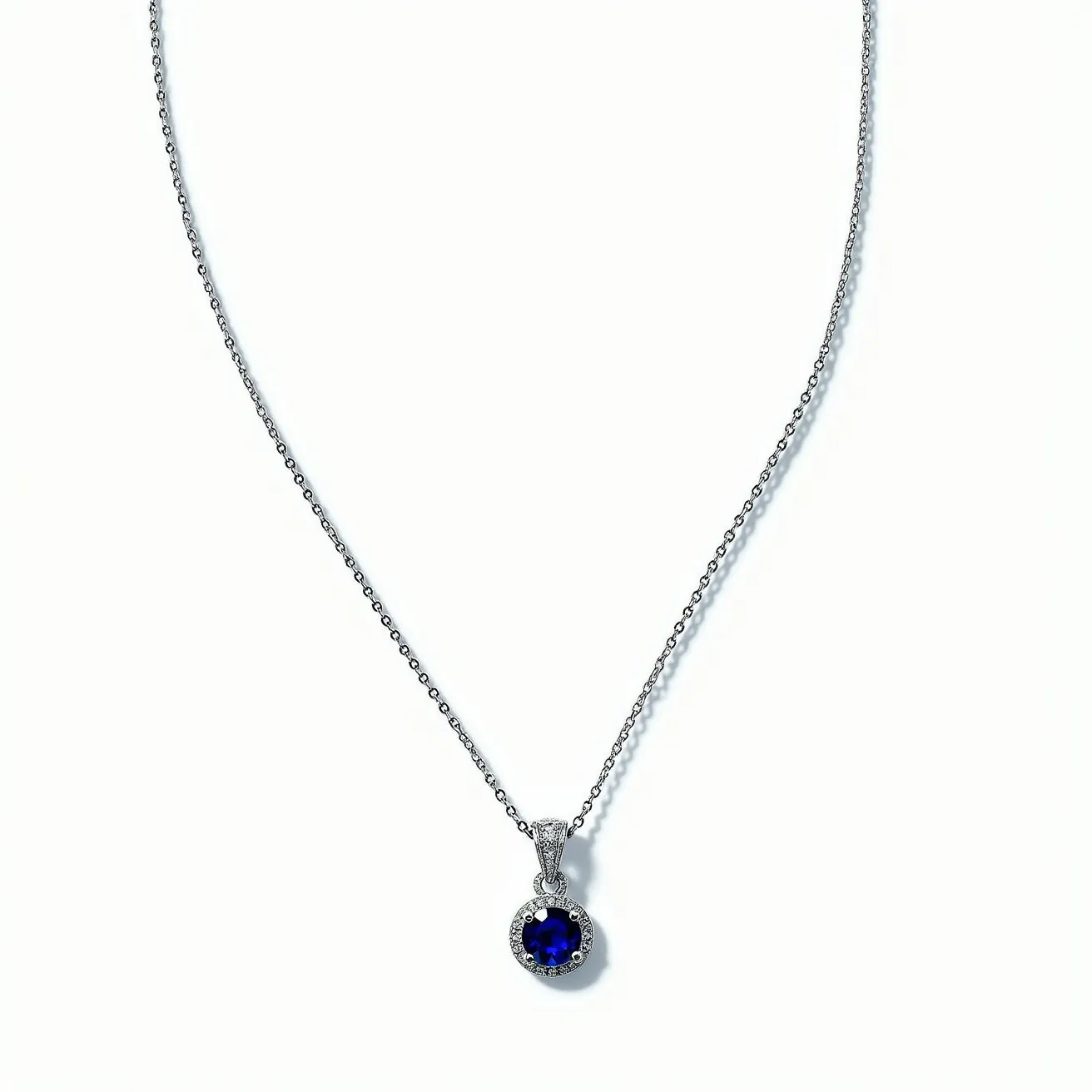 This sapphire necklace features a delicate chain, likely made of white gold or platinum, which adds a subtle elegance to the piece. The centerpiece is a round-cut sapphire, exhibiting a deep blue hue and surrounded by a halo of smaller diamonds that amplify its brilliance through a prong setting. The pendant is suspended from the chain by a polished bail that seamlessly integrates into the design. The clasp is a classic lobster clasp, ensuring both security and ease of wear, making it a sophisticated and timeless accessory.