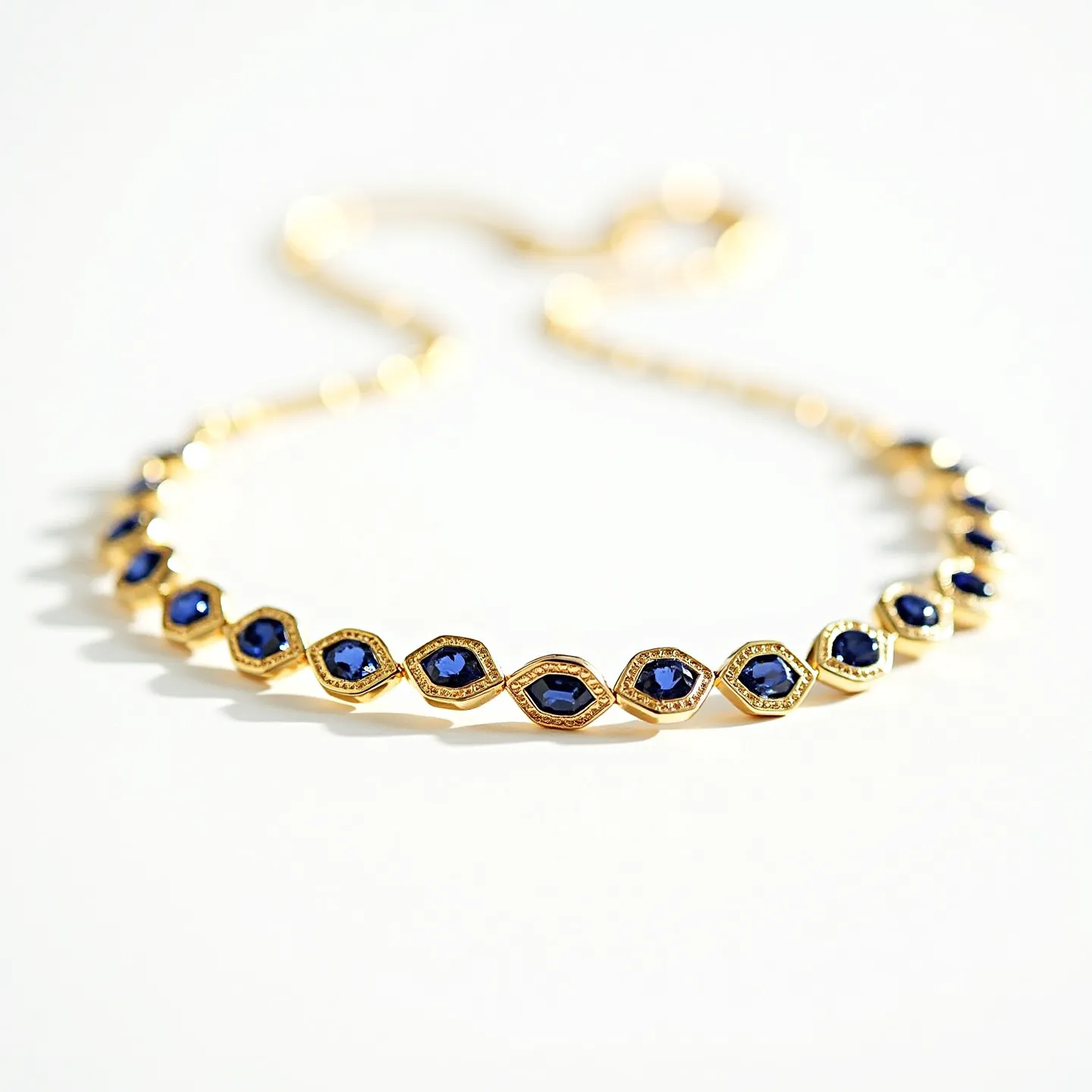 This sapphire necklace features an elegant arrangement of deep blue sapphire gemstones. These stones are oval-shaped and set in a gold setting, emphasizing their rich color and brilliance. The gold metal surrounding the gemstones provides a contrast that enhances the visual appeal of the sapphires. The necklace is likely secured with a delicate and matching gold clasp, ensuring both style and functionality. The design suggests a sophisticated and timeless piece, perfect for formal occasions.