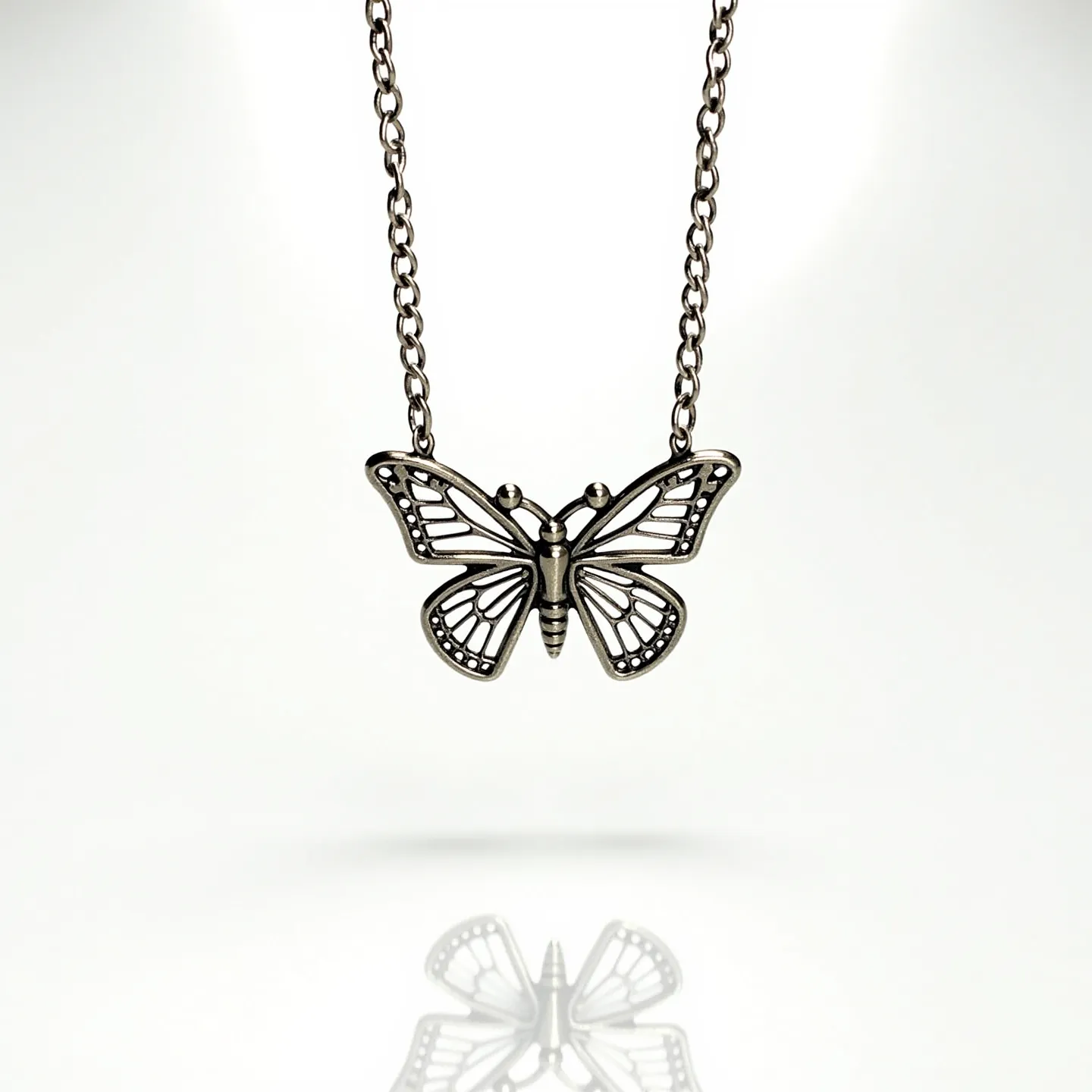 This silver butterfly necklace features a delicately crafted butterfly pendant with an intricate openwork design, highlighting the elegance and beauty of its form. The pendant is crafted from silver, giving it a polished and shiny appearance. The necklace has a sturdy chain that complements the pendant's design, likely connected with a standard clasp for easy wearing. The pendant does not feature any stones or gems, emphasizing the smooth, metallic texture of the silver. The combination of the detailed butterfly motif and the simplicity of the metalwork creates a sophisticated accessory that can enhance various outfits.