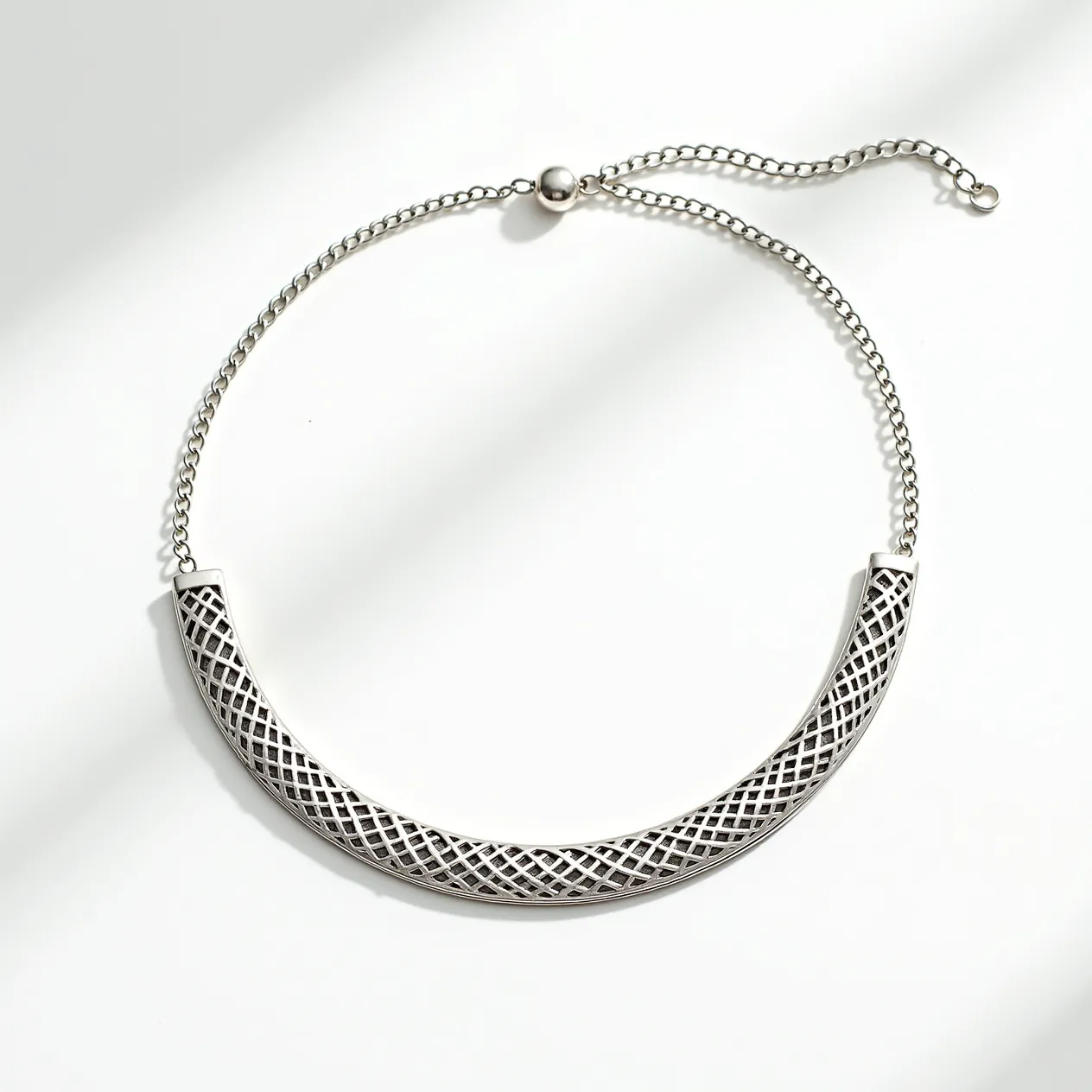 This silver choker necklace features an intricately designed central band with a lattice pattern, creating a refined and elegant appearance. It is composed of polished silver links that form a sleek, flexible chain. The necklace is secured with an adjustable sliding ball clasp, allowing for a customizable fit around the neck. The absence of gems or stones keeps the design minimalistic yet sophisticated, emphasizing the artistry of the silverwork.