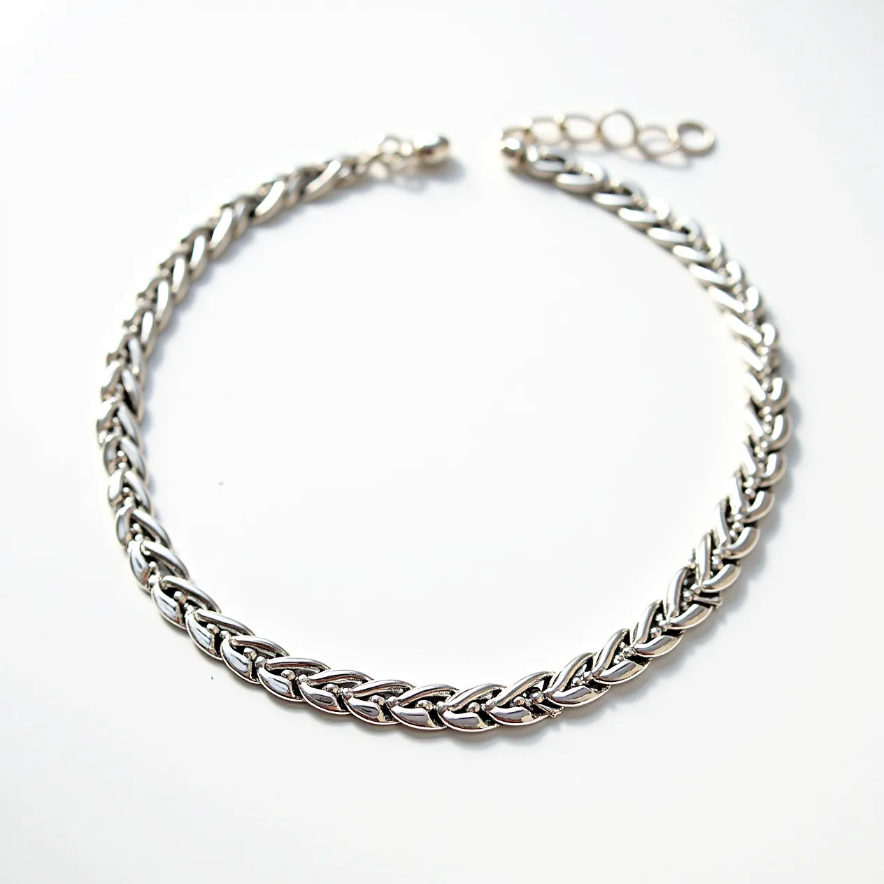 This silver choker necklace features an intricately woven chain design, showcasing a polished finish that enhances its reflective quality. The necklace comprises sterling silver links forming a tight braid pattern, offering both flexibility and durability. It is secured with a lobster clasp, providing a reliable fastening mechanism, and includes an adjustable chain extension for versatile sizing. The choker does not incorporate any gems or stones, focusing solely on the elegance of the silver material.