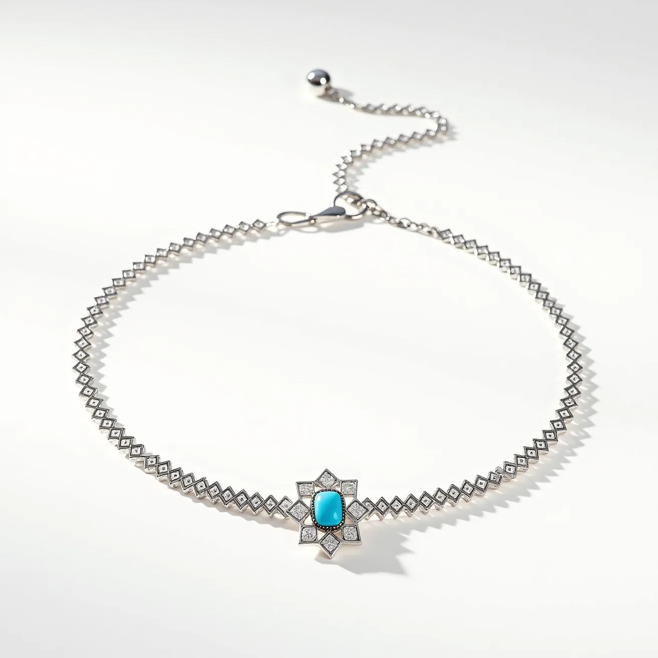 This silver choker necklace features a geometric diamond-shaped design, meticulously crafted from silver material. At its center lies a prominent blue stone, possibly turquoise, cut in a cabochon style, and set within a star-shaped arrangement that accentuates its striking color. Each point of the star is adorned with small, sparkling gems, enhancing the necklace's elegance. The choker is equipped with a lobster clasp for secure fastening, and an adjustable chain with a rounded silver bead at the end, allowing for a custom fit.