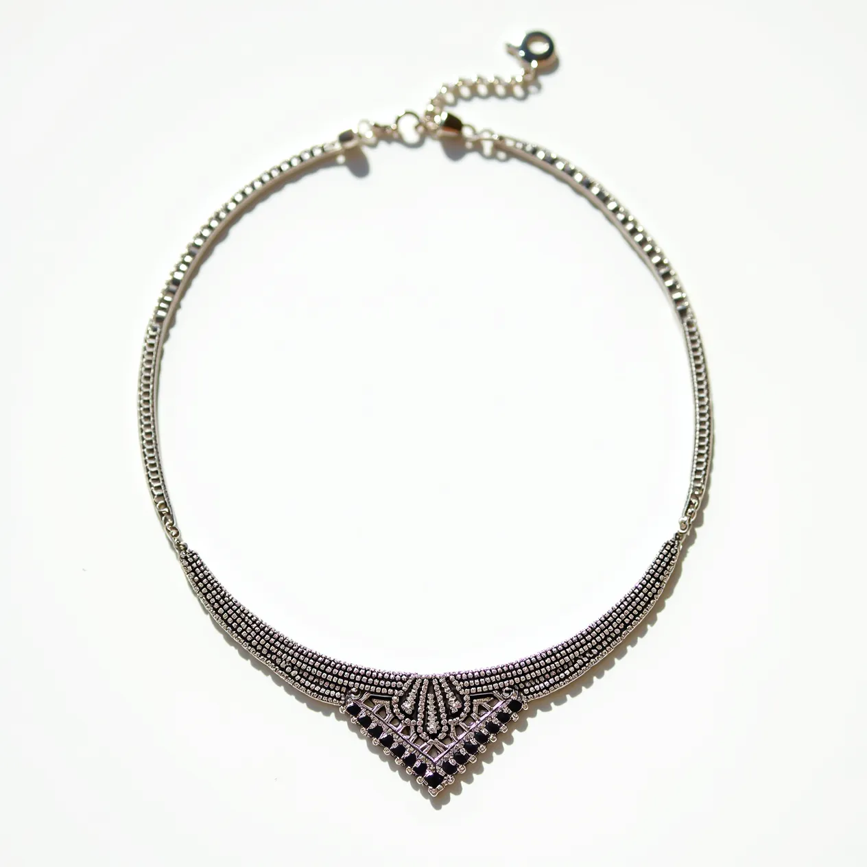 This silver choker necklace showcases intricate detailing with its delicate beading forming a broad, elegant pattern at the center. The necklace appears to be crafted from sterling silver, giving it a polished, reflective finish. A series of small, dark gemstones or crystals are embedded within the central pattern, accentuating its geometric design. These stones are likely round-cut, contributing a subtle sparkle to the piece. The choker is secured with an adjustable chain and clasp mechanism, ensuring a customizable fit while adding a touch of elegance to its overall design.