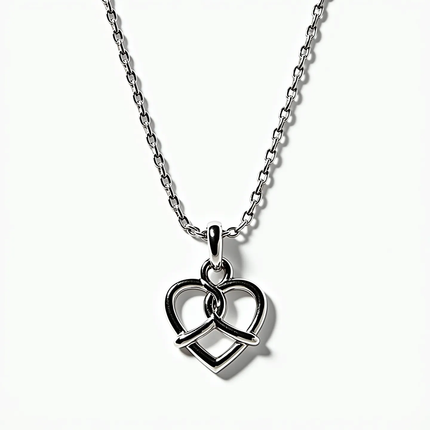 This silver heart necklace features a polished, interwoven heart-shaped pendant crafted from sterling silver. The design consists of two overlapping heart outlines, creating a simple yet elegant motif. Attached to a delicate silver chain, the necklace is secured with a standard spring ring clasp, ensuring easy fastening. The minimalist design with its shiny finish makes it a versatile piece suitable for various occasions.