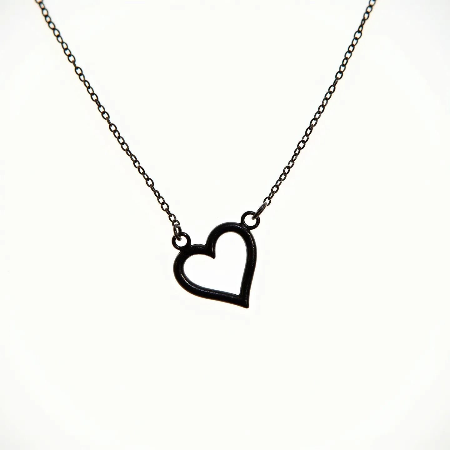 This silver heart necklace features a delicate, open heart pendant crafted from polished silver, providing a sleek and modern look. The pendant is smoothly outlined, hanging elegantly from a fine, silver chain that is light and understated, complementing the heart motif. No visible gemstones are embedded in the design, allowing the simplicity of the silver to speak for itself. The pendant is securely attached to the chain with small loop connectors, ensuring durability and fluid movement. The chain likely includes a standard clasp, typical of necklaces of this style, ensuring ease of wear.