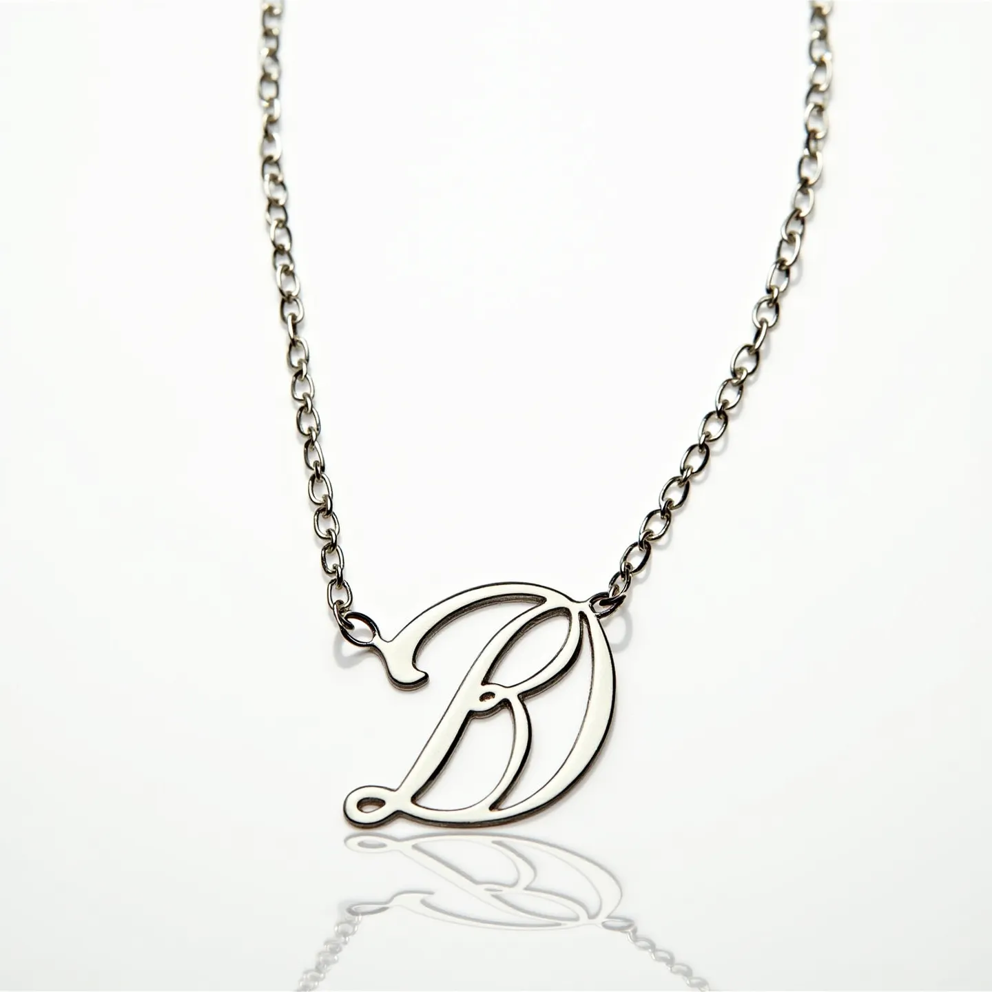 This silver initial necklace features a delicately crafted initial "B," made from polished sterling silver, exhibiting a sleek and refined look. The pendant is attached seamlessly to a matching silver chain, which is composed of interconnected links that provide a sturdy yet elegant appearance. The initial is styled in an elegant font that adds a personalized touch to the overall design. The necklace is fastened using a secure lobster clasp, ensuring ease of wear and durability. Overall, the necklace presents a classic and timeless piece, perfect for adding a personal touch to any ensemble.